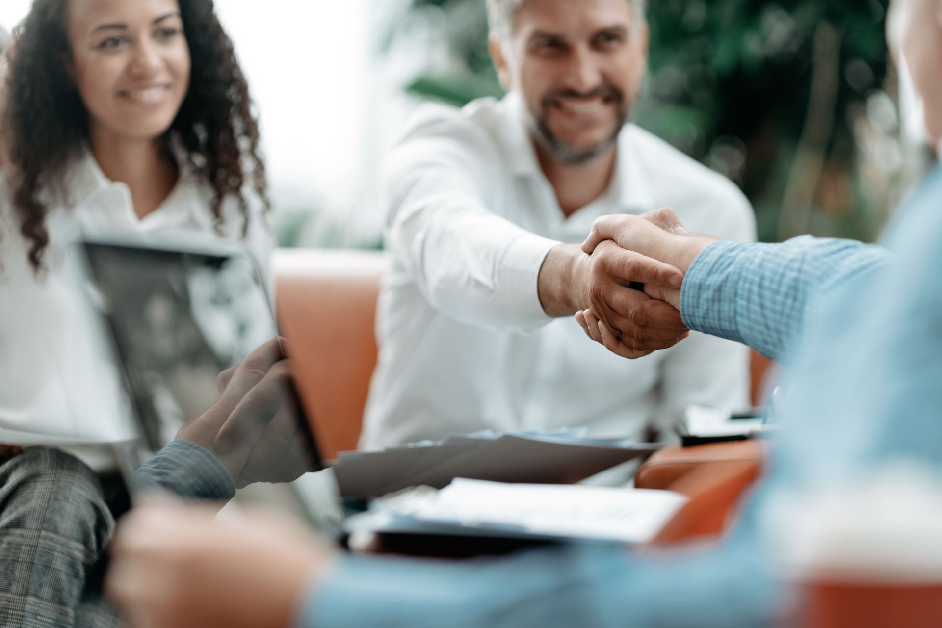 Business partners are shaking hands with their insurance provider after reviewing the policy. Business partners are shaking hands with their insurance provider after reviewing the policy.