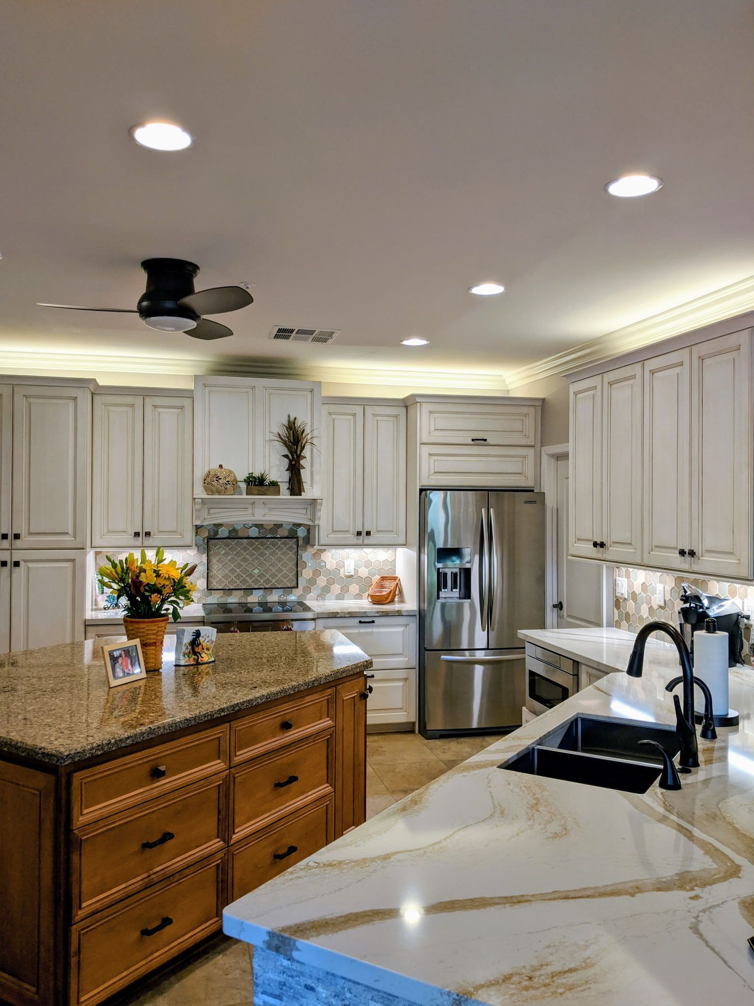 Spacious kitchen with a large island, white cabinets, stainless steel appliances, and granite countertops.
