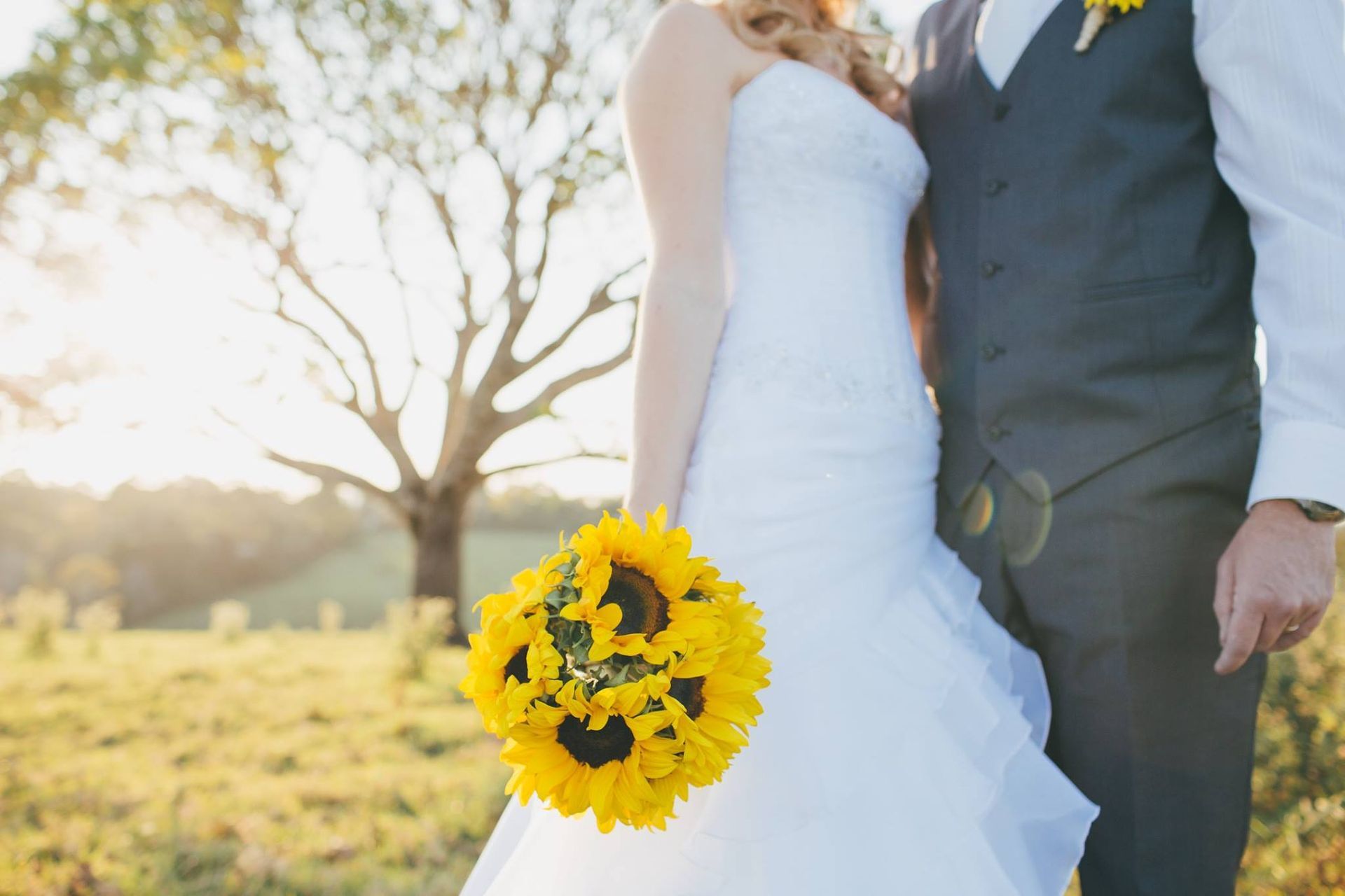 A Bride and Groom Are Standing and the Bride is Holding a Bouquet of Sunflowers — Suncoast Flowers in Caloundra, QLD