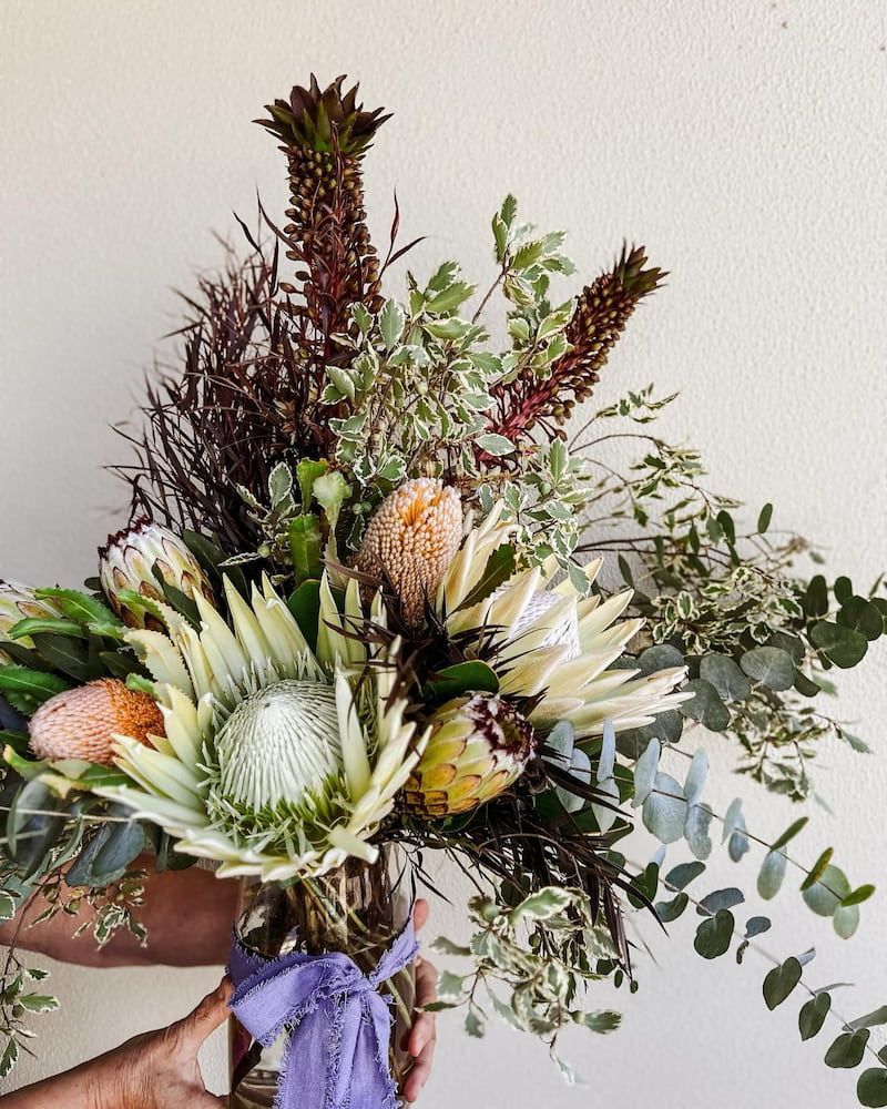A Person is Holding a Bouquet of Flowers in a Vase — Suncoast Flowers in Birtinya, QLD