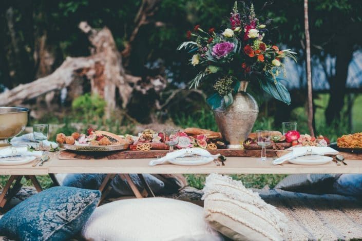 A Long Table With Plates of Food and a Vase of Flowers on It — Suncoast Flowers in Birtinya, QLD