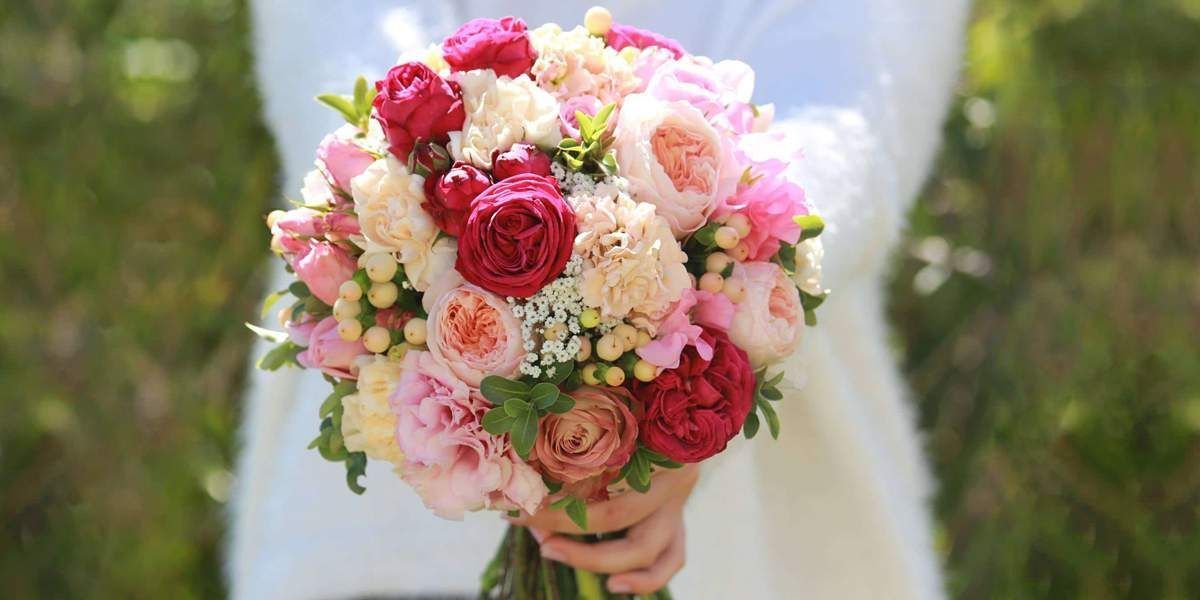 A Bride is Holding a Bouquet of Flowers in Her Hands — Suncoast Flowers in Maroochydore, QLD