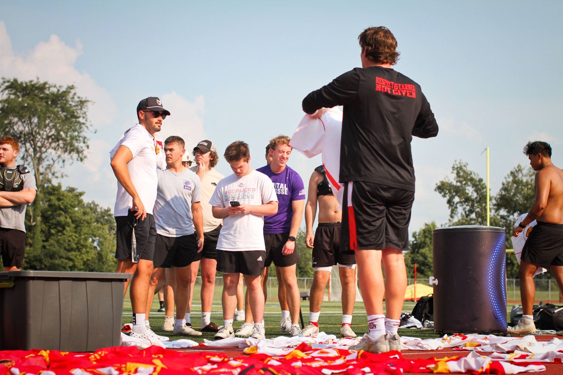 Coach addressing a group of students outdoors amid scattered red confetti