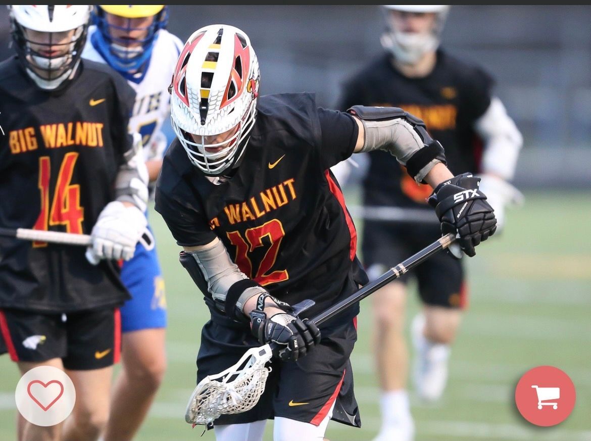 Lacrosse players in black and red Big Walnut uniforms sprinting during a game