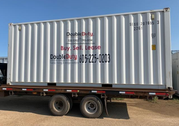 A white shipping container with double duty written on it