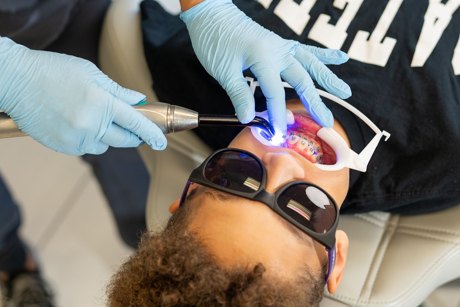 Orthodontist at Brinley Orthodontics expertly adjusting braces on a patient’s teeth, demonstrating precision and care.