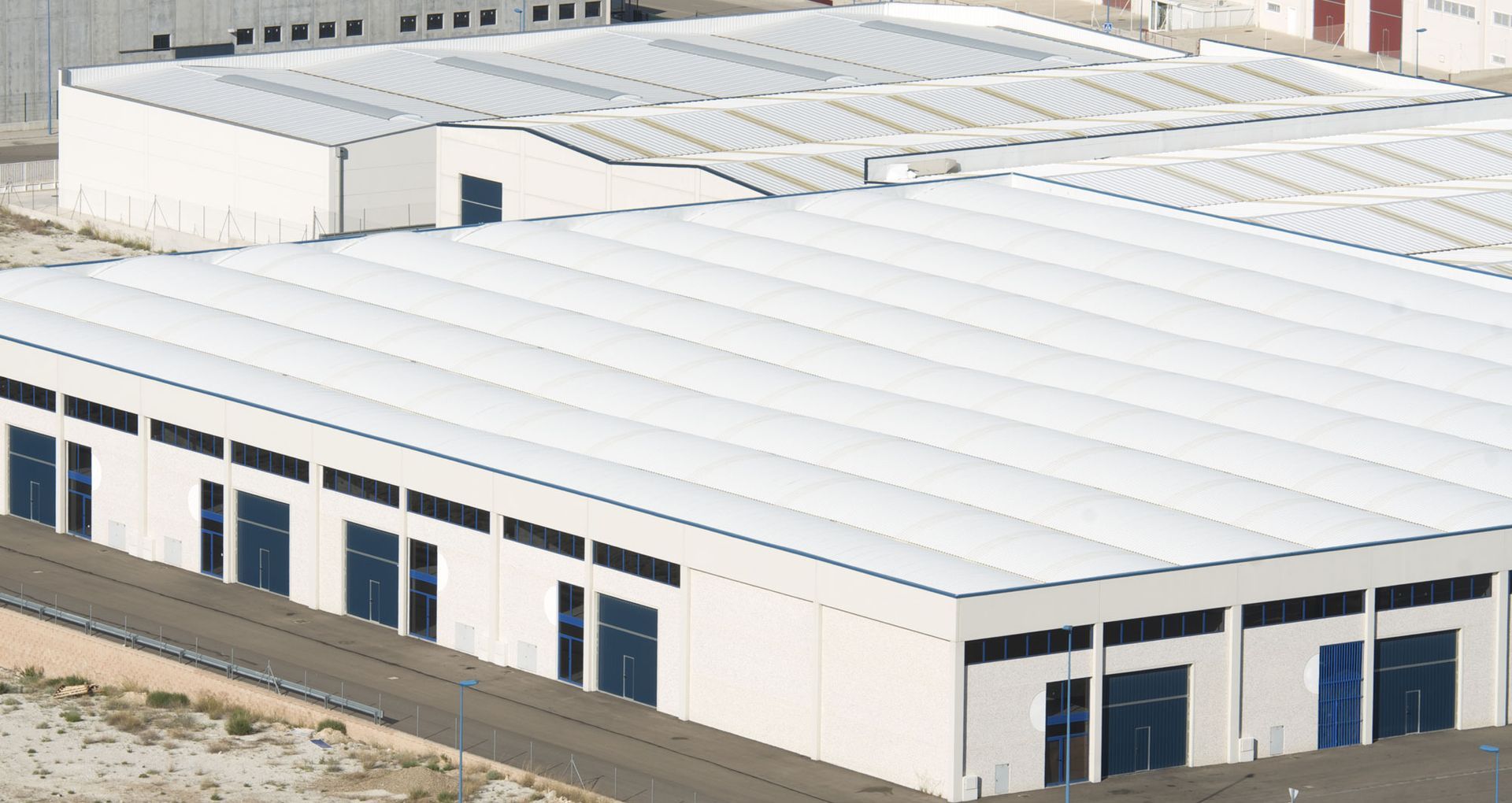 White industrial buildings with corrugated metal roofs.
