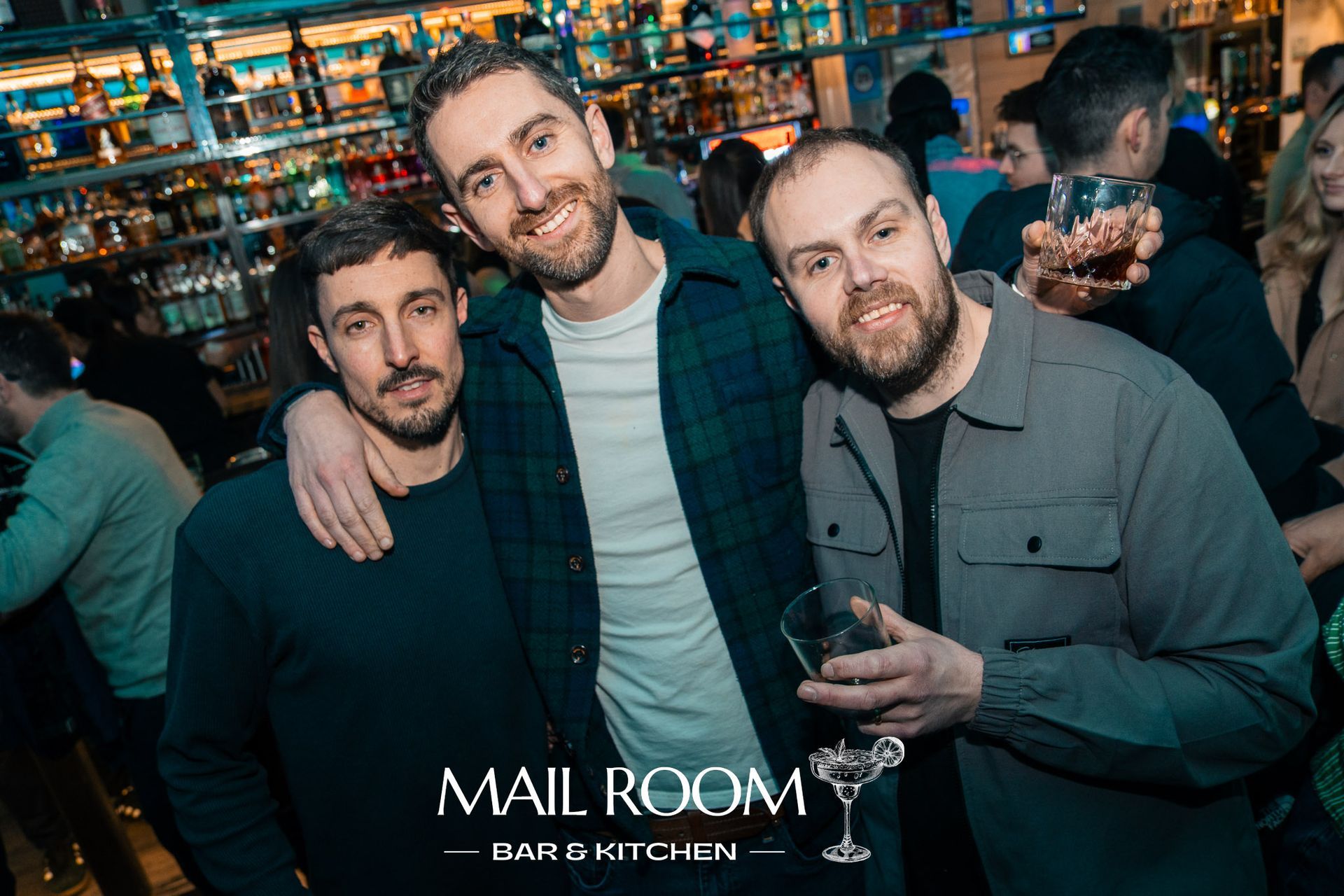 Three men are posing for a picture in a bar.