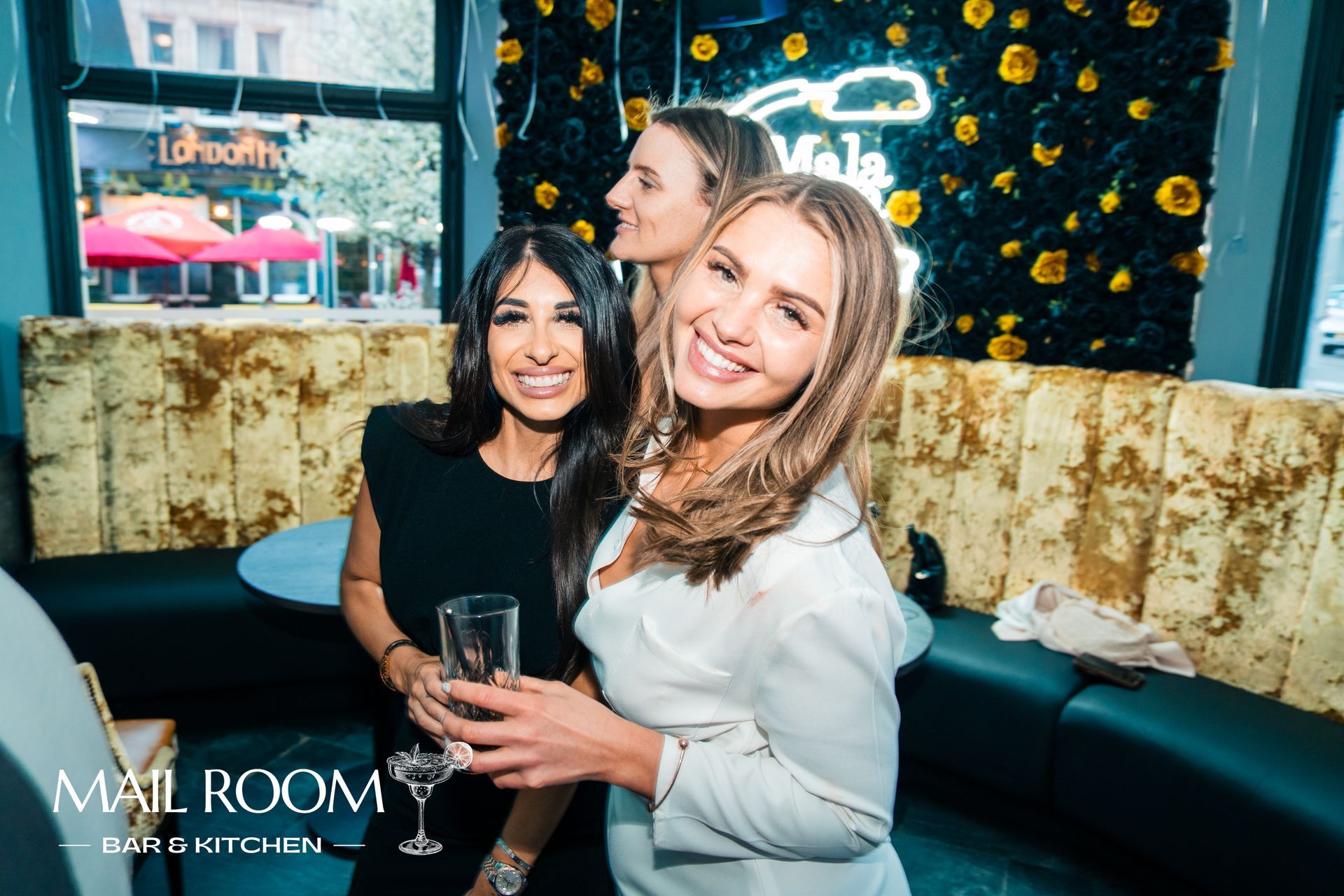 Three women are posing for a picture in a restaurant.