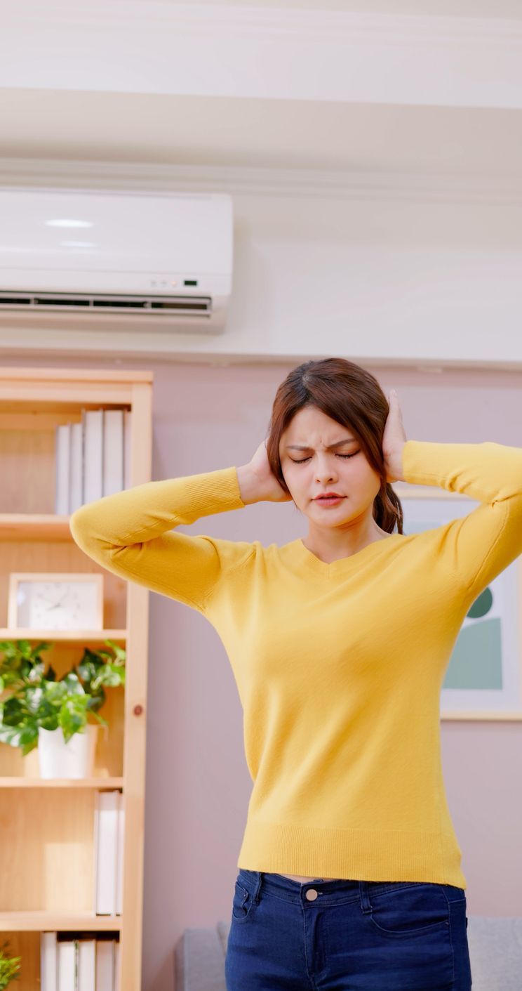 A technician checking an air conditioner and finding a leak, indicating the need for AC repair in Mi