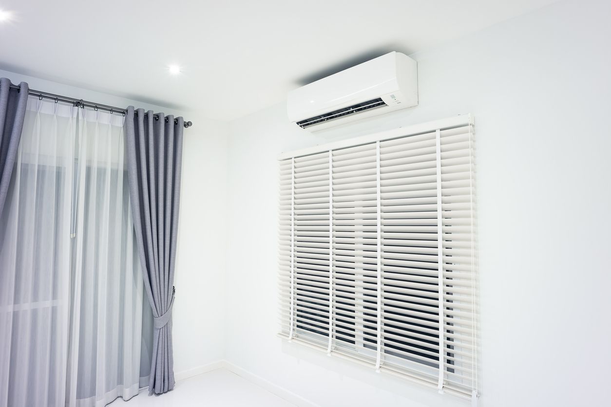 Bright white room with striped curtains, window blinds, and a wall-mounted air conditioner