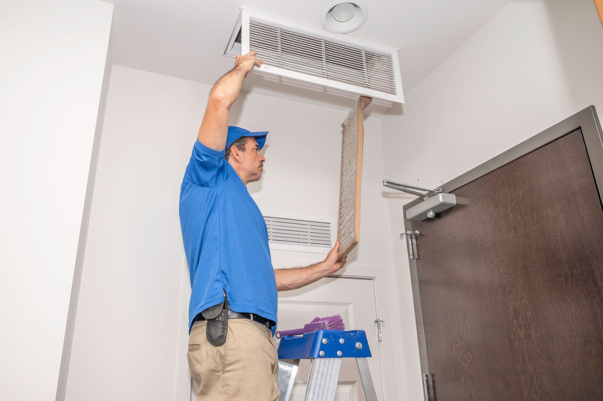 HVAC technician inspecting an indoor air quality system and dehumidifier in a Miami, Florida.