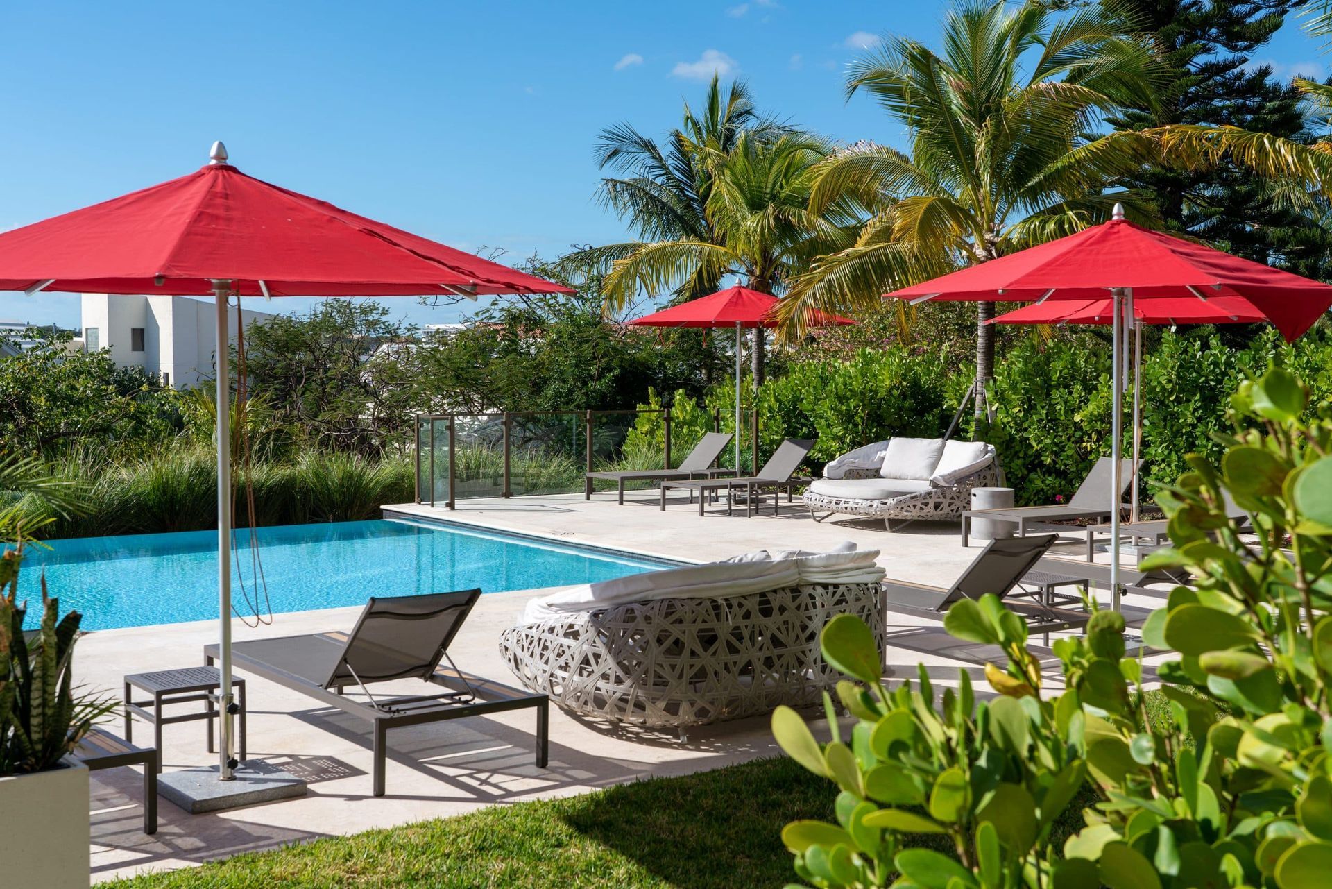 A living room with a large sectional couch and a ceiling fan in one cable beach Nassau Bahamas