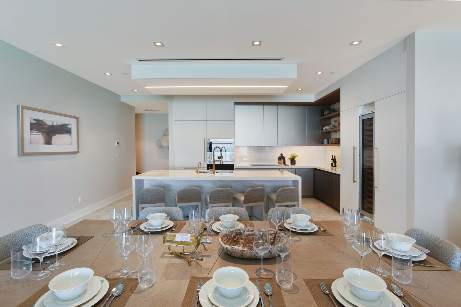 A dining room table with plates , bowls , glasses and silverware in a kitchen in Bond Vacations Nassau Bahamas