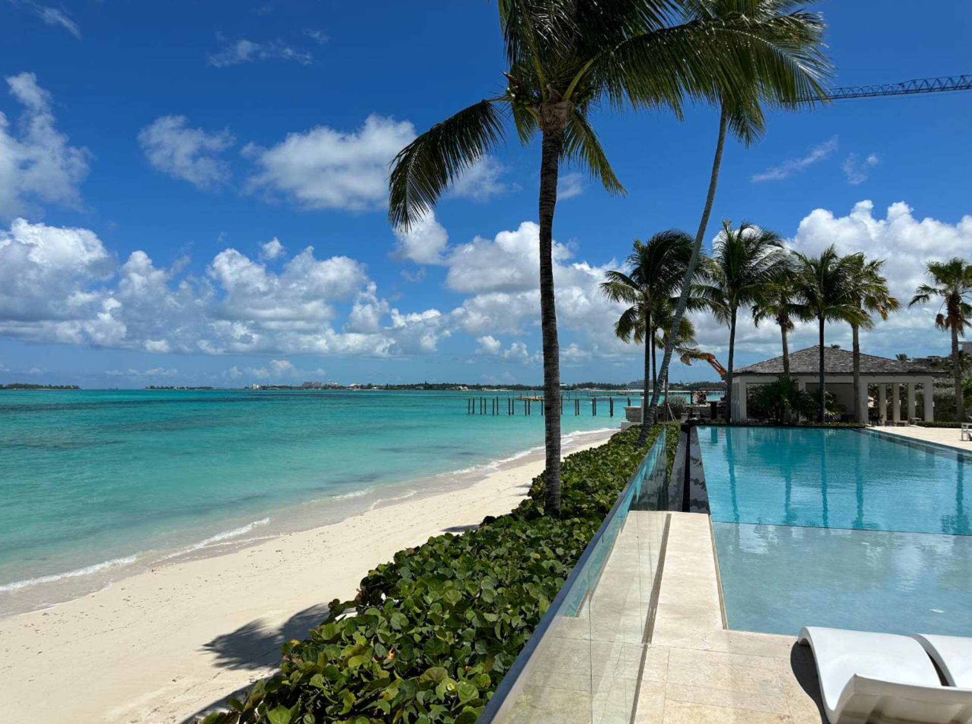 A spacious living room with a couch, table, chairs and stairs in one cable beach Nassau Bahamas