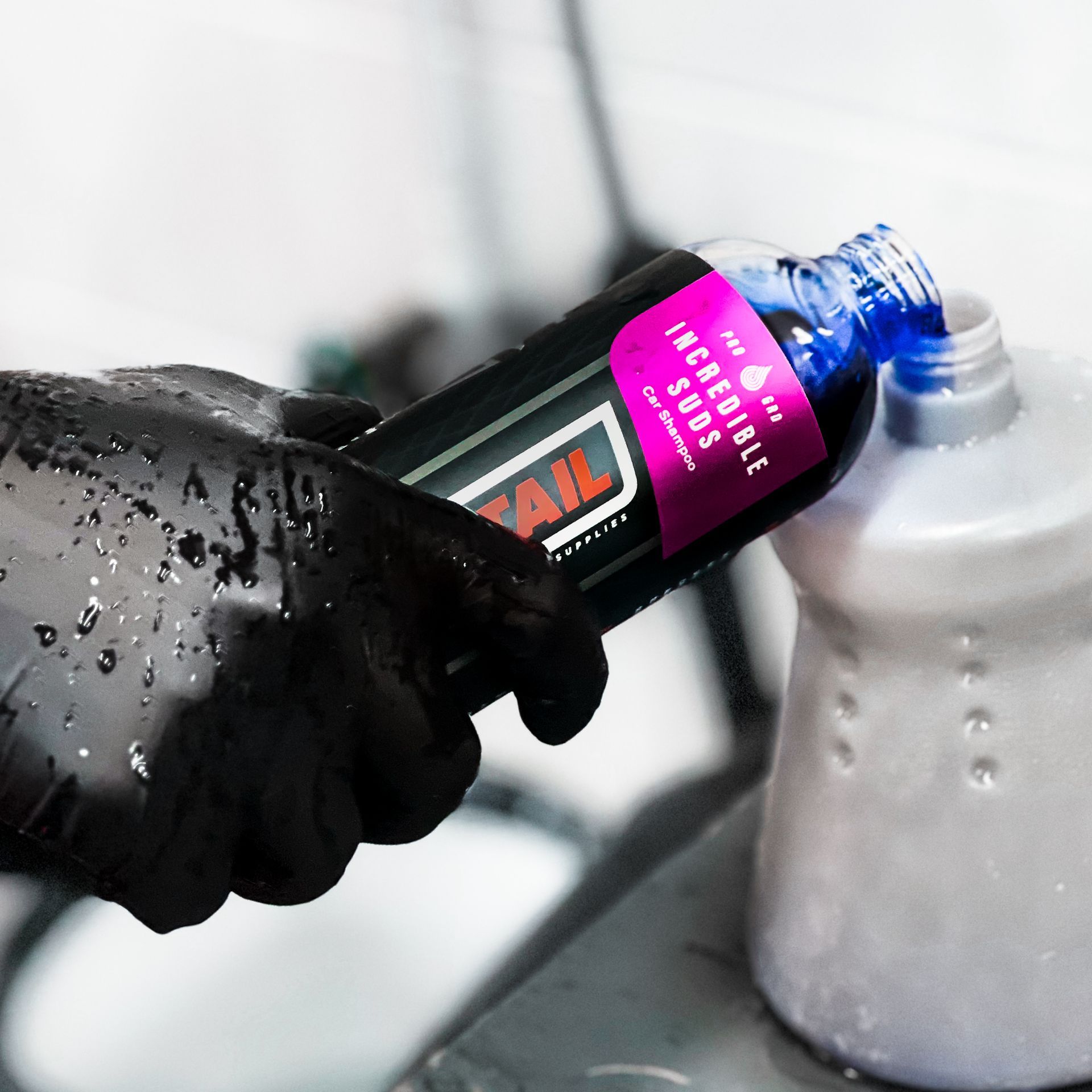 A person is pouring liquid from a tail bottle