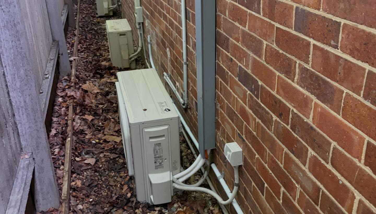 Outdoor Air-conditioning Units Beside A Brick Wall And Fence — Escarpment Air in Mount Saint Thomas, NSW