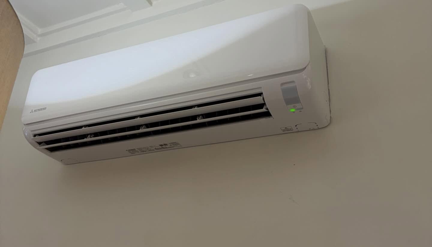 Wall-mounted White Air Conditioner On A Beige Wall — Escarpment Air in Kiama, NSW