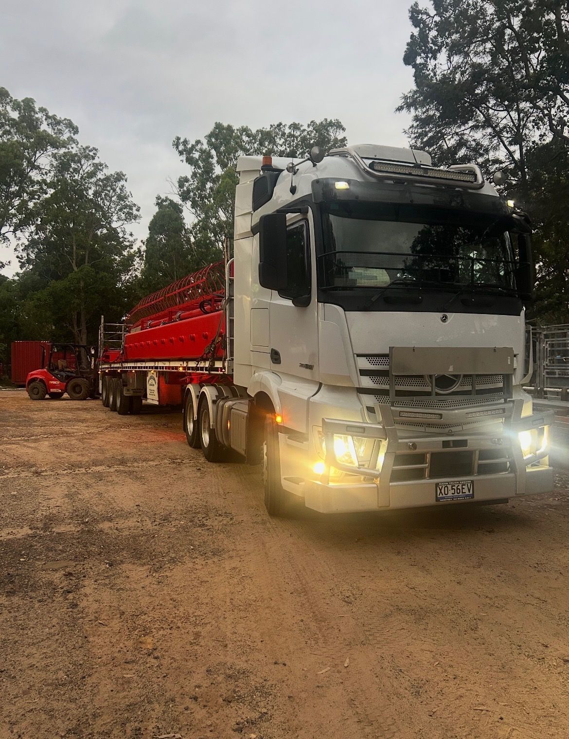 White Semi-truck With Red Trailer on a Dirt Road in a Wooded Area — Western Pacific Operations in Grafton, NSW