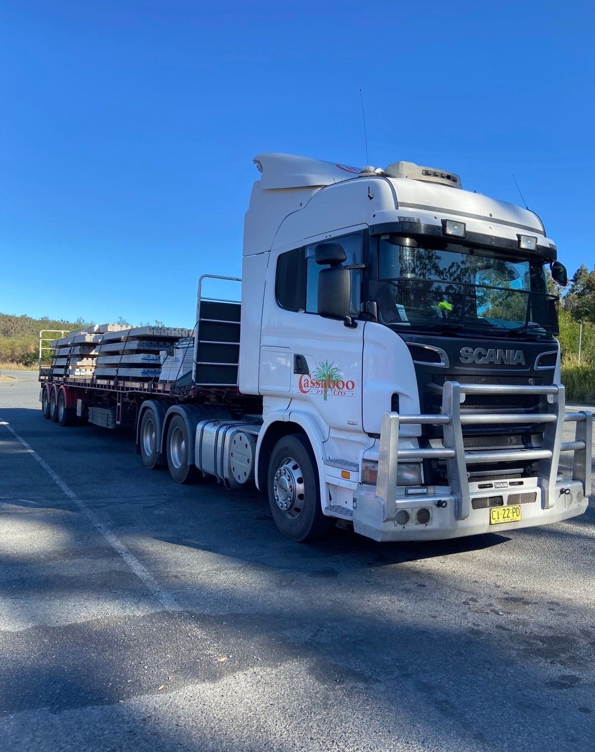 White Semi-truck Hauling a Long Flatbed Trailer on a Sunny Road — Western Pacific Operations in Brisbane, QLD
