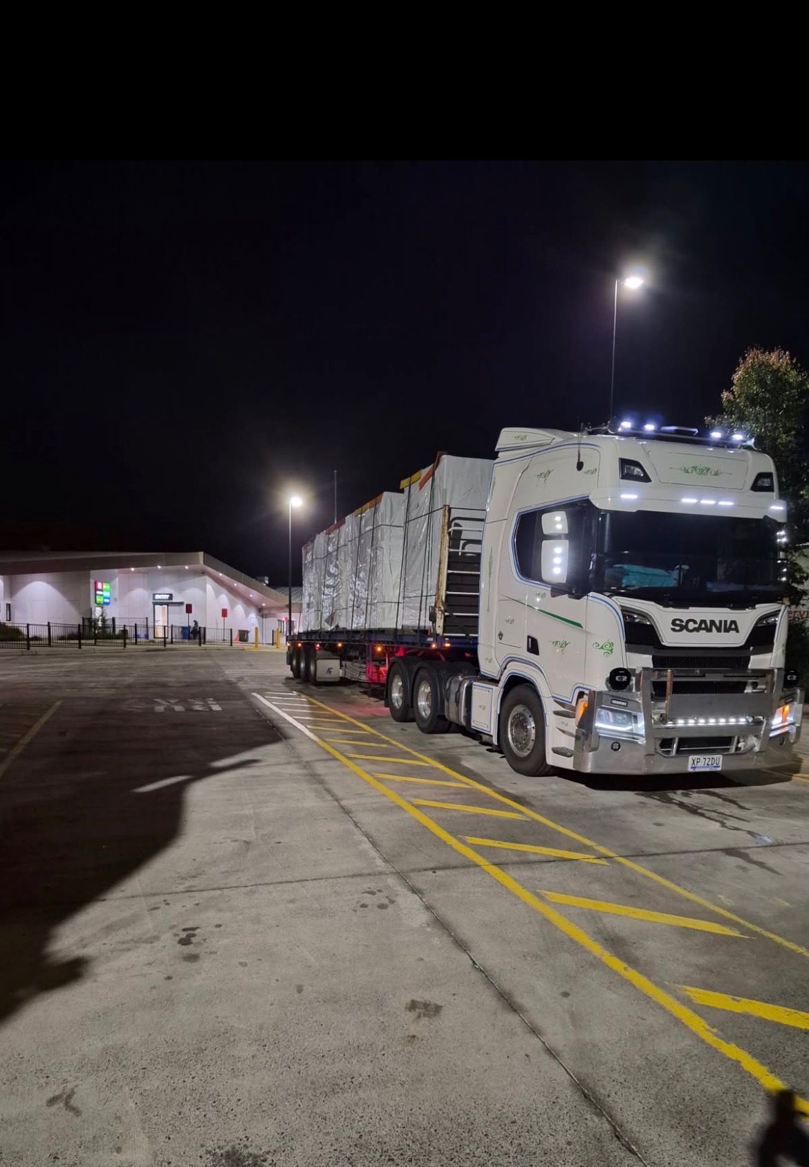 White Scania Semi-truck With Trailer Parked at a Lit Warehouse — Western Pacific Operations in Townsville, QLD