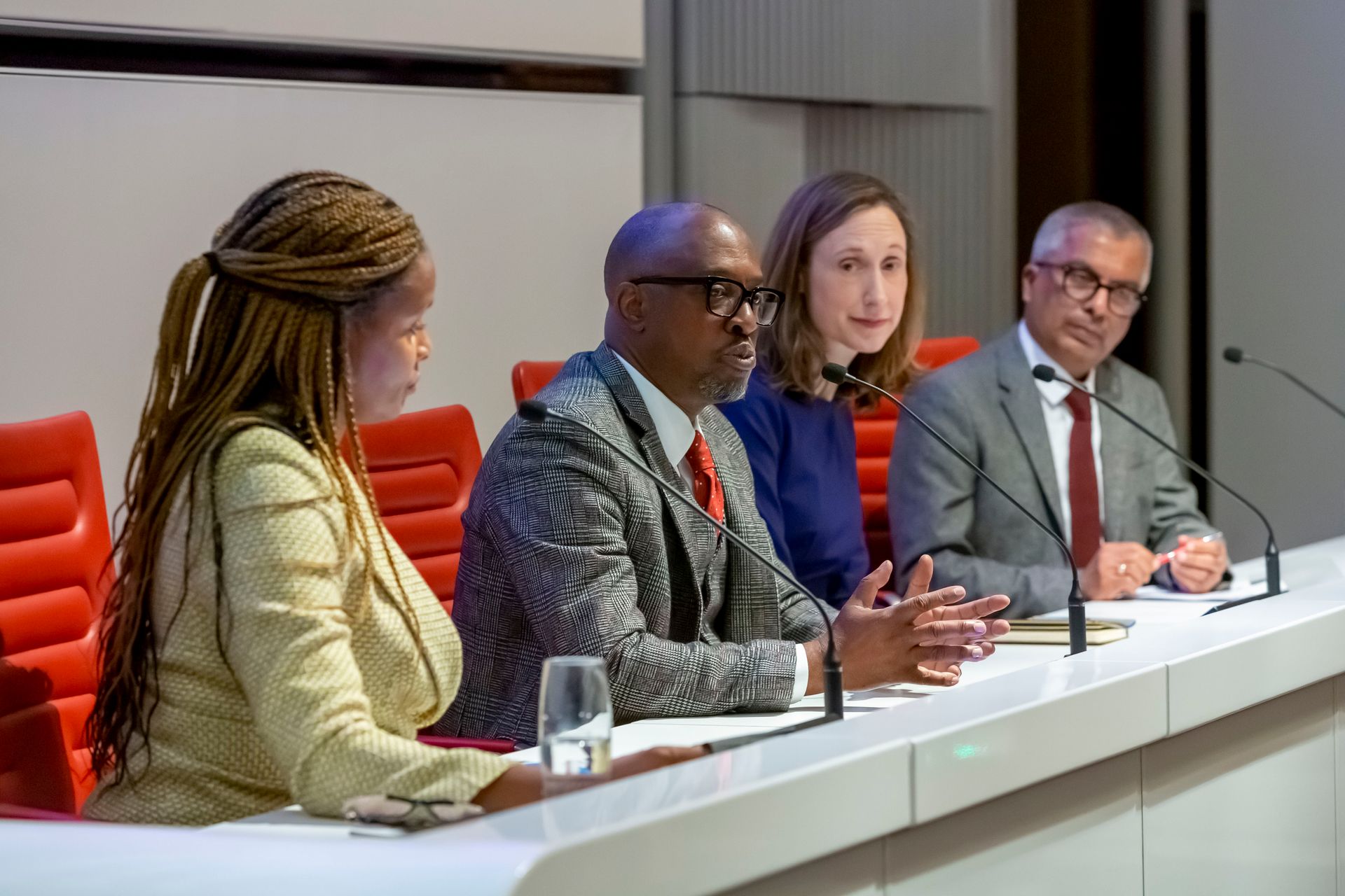 A group of people are sitting at a table with microphones.