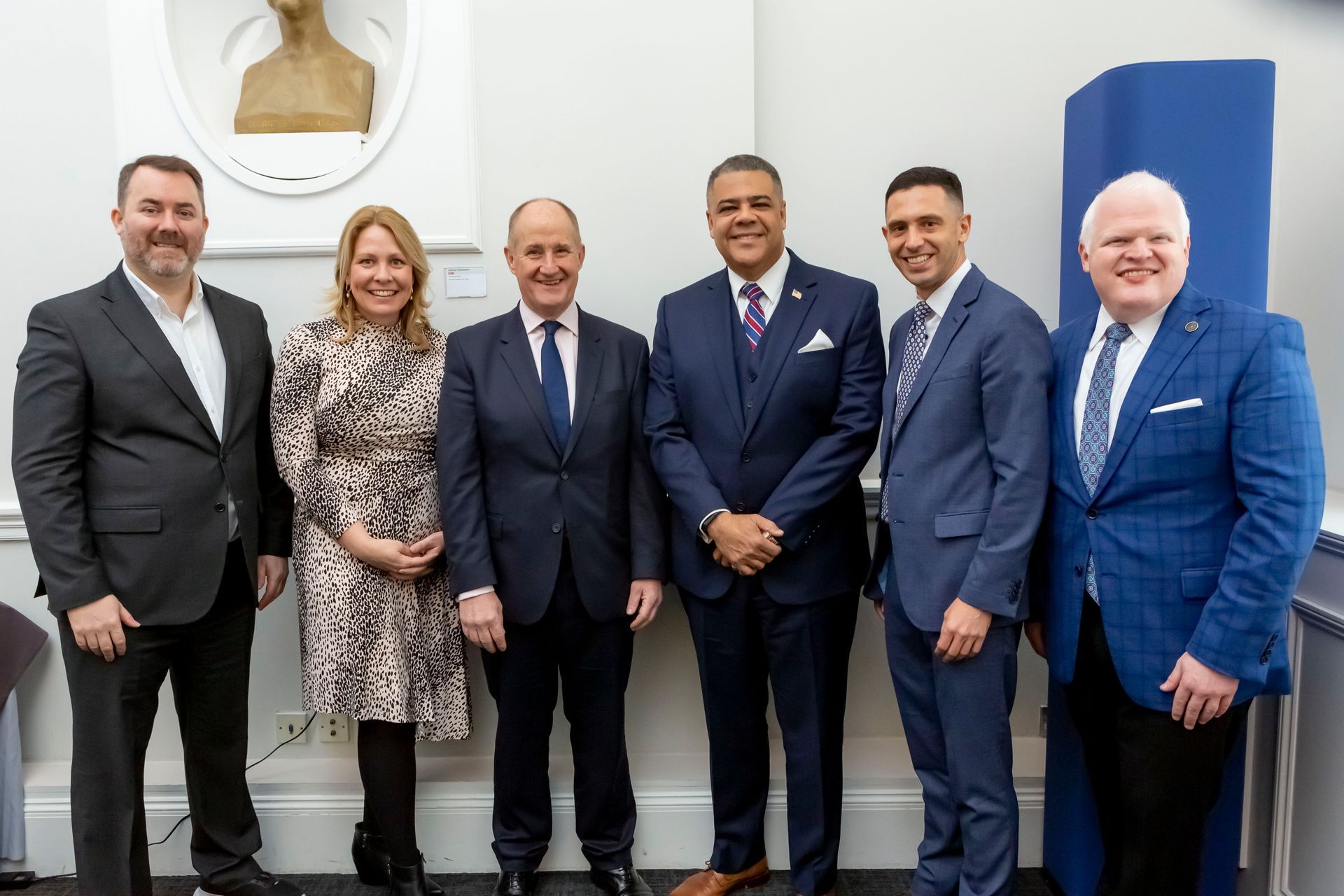 A group of people in suits and ties are posing for a picture.