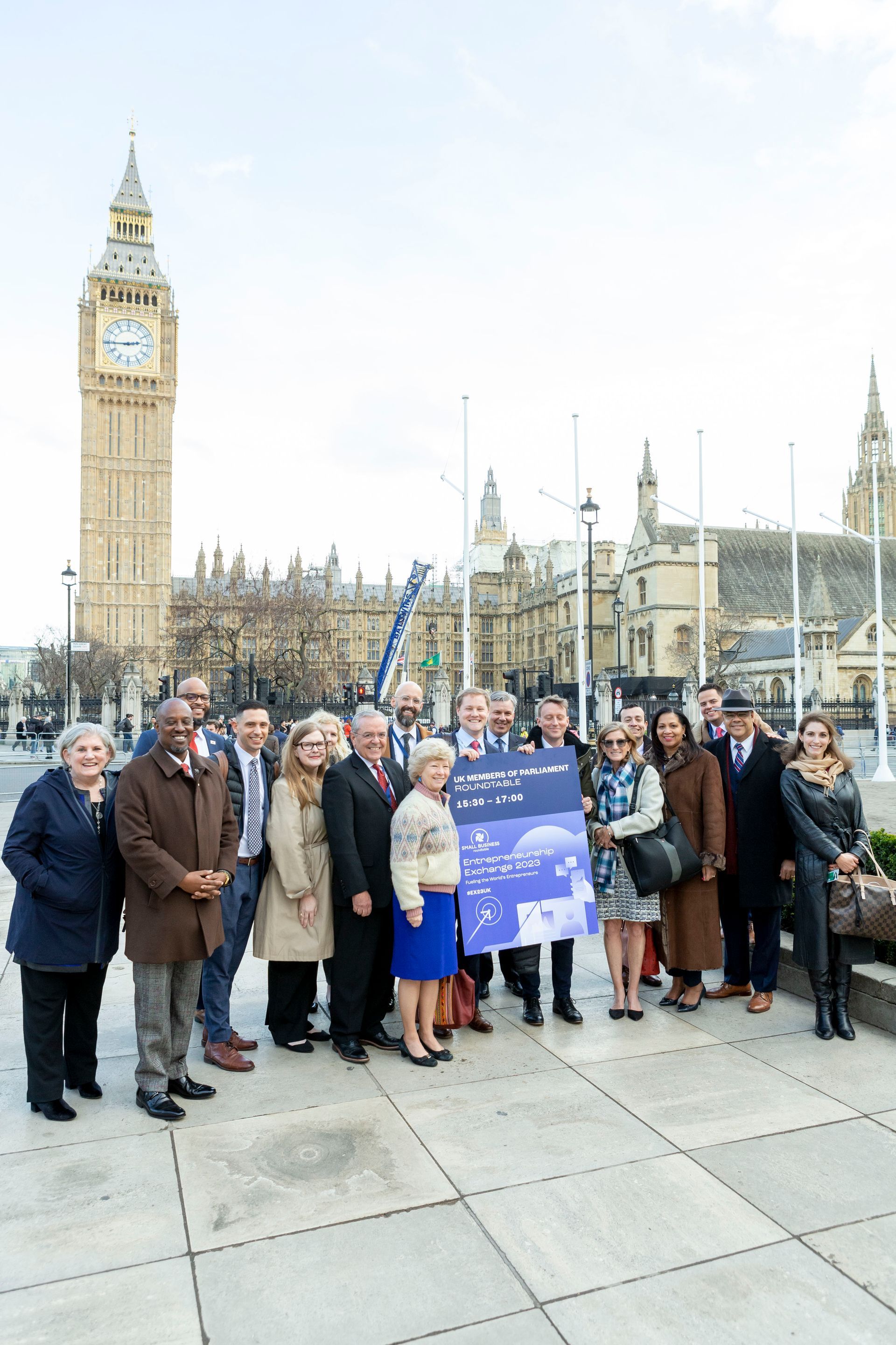 A group of people are posing for a picture in front of big ben in london.