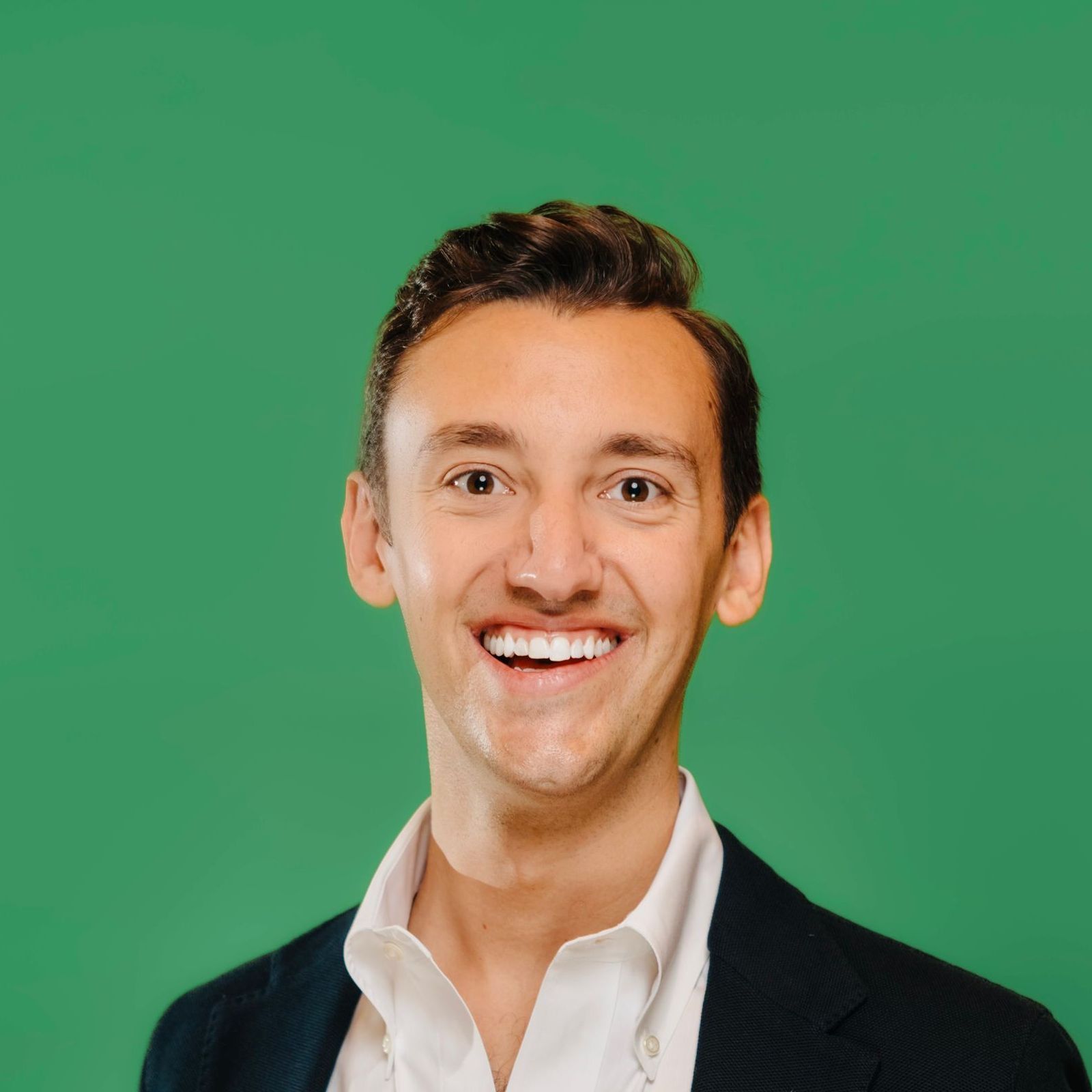 A man in a suit and tie is smiling for the camera.