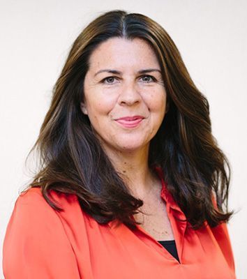The woman is wearing a red shirt and smiling for the camera.