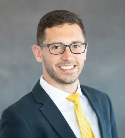 A man in a suit and tie is smiling for the camera.