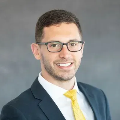 A man in a suit and tie is smiling for the camera.
