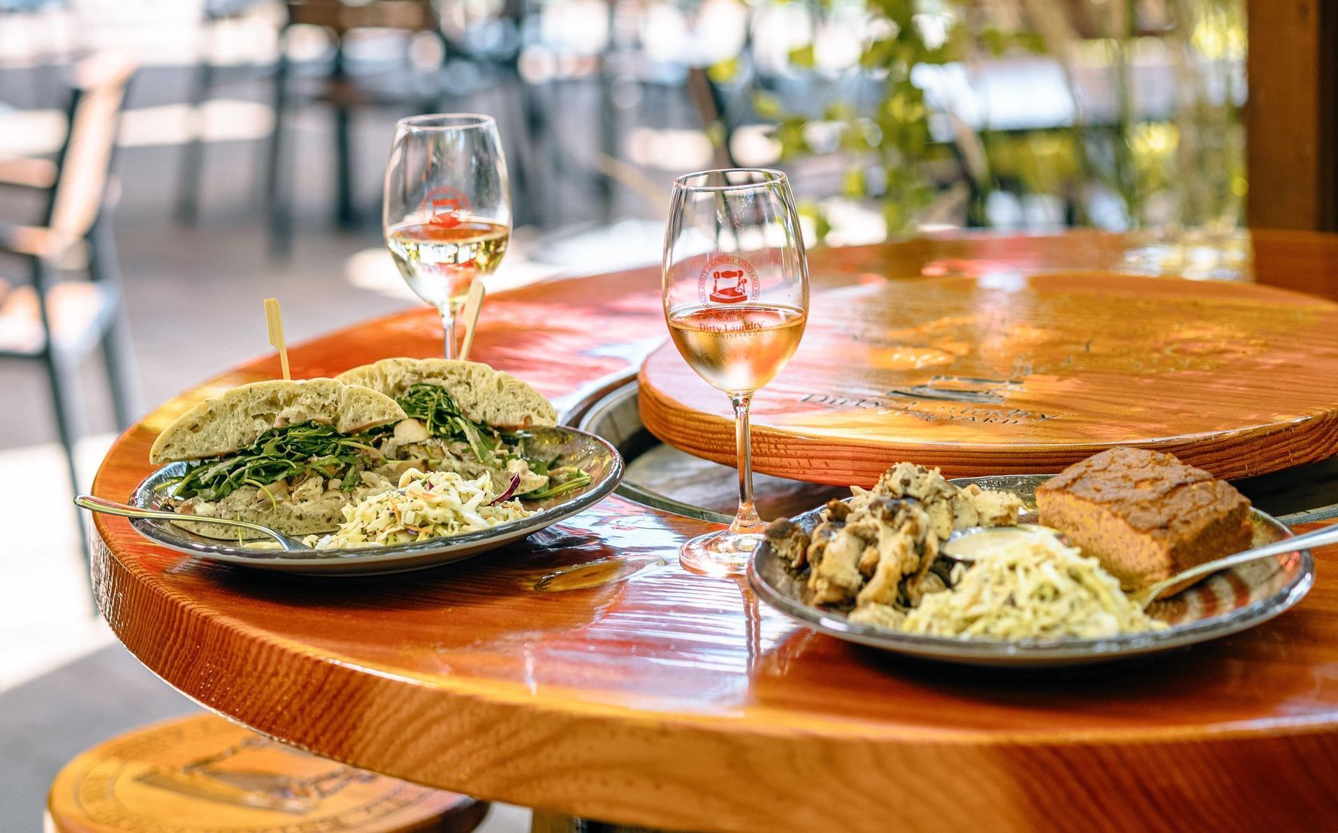 A wooden table topped with plates of food and wine glasses.