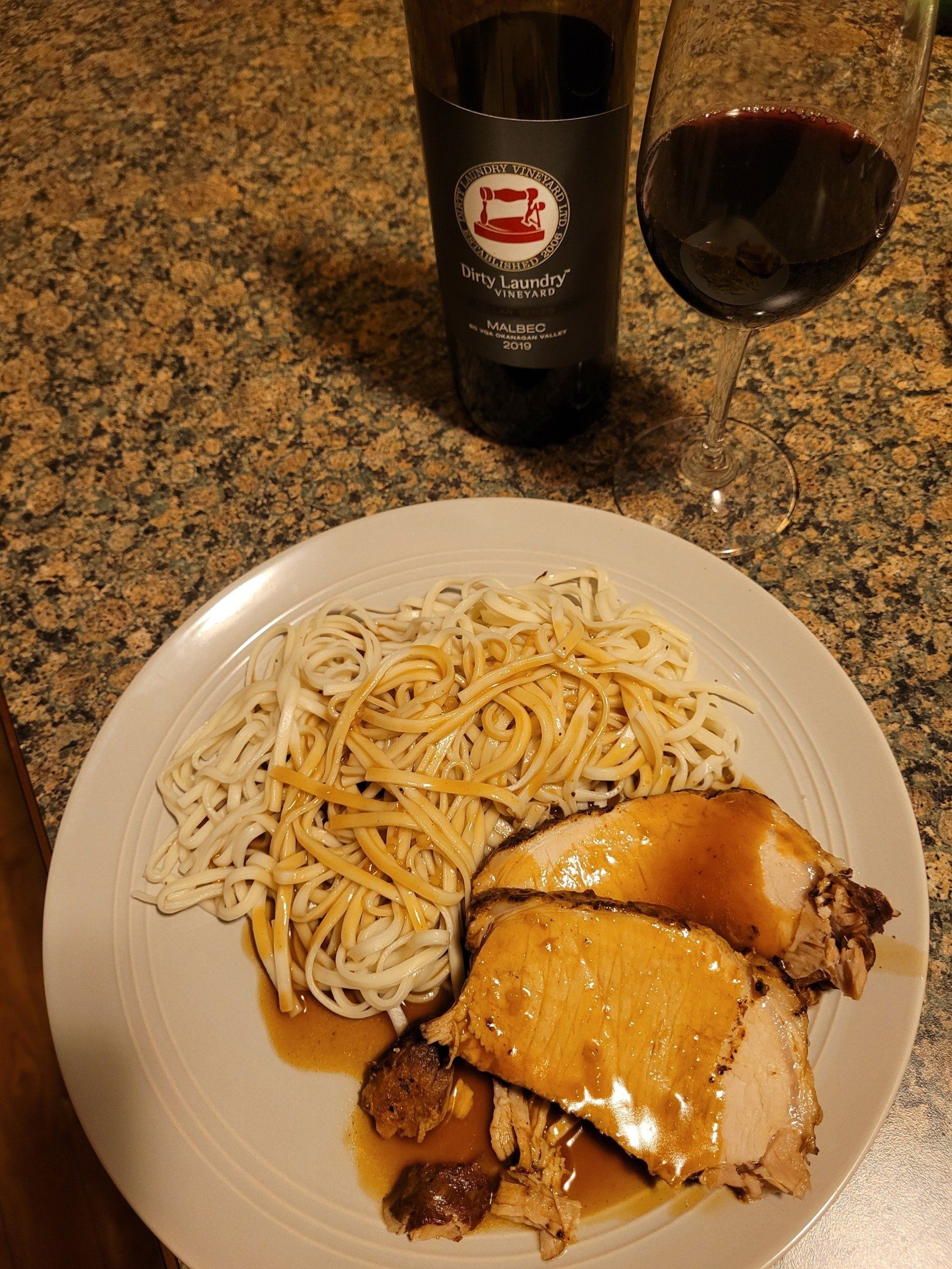 A plate of food with a bottle of wine in the background