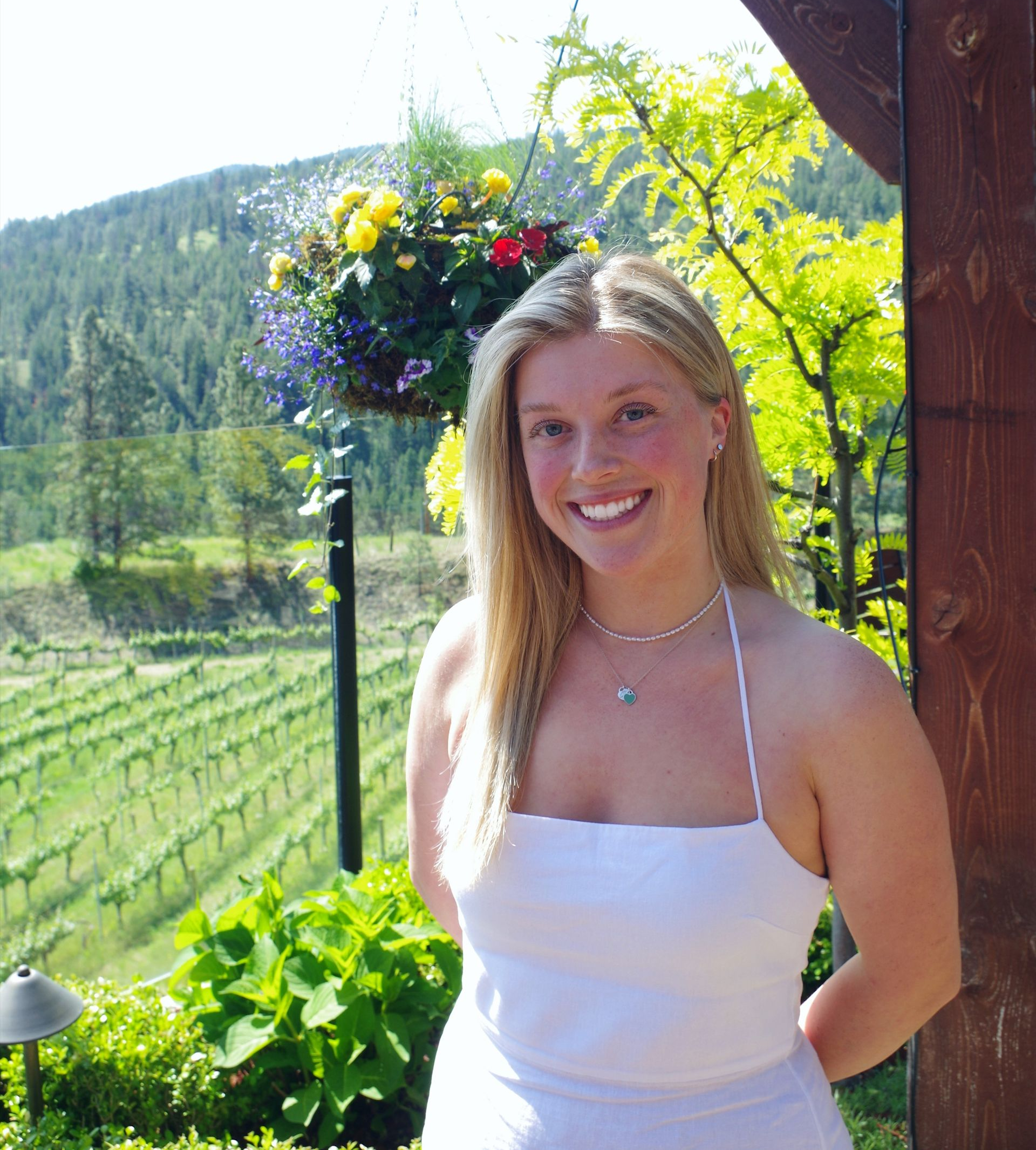 A woman wearing glasses is holding a glass of wine