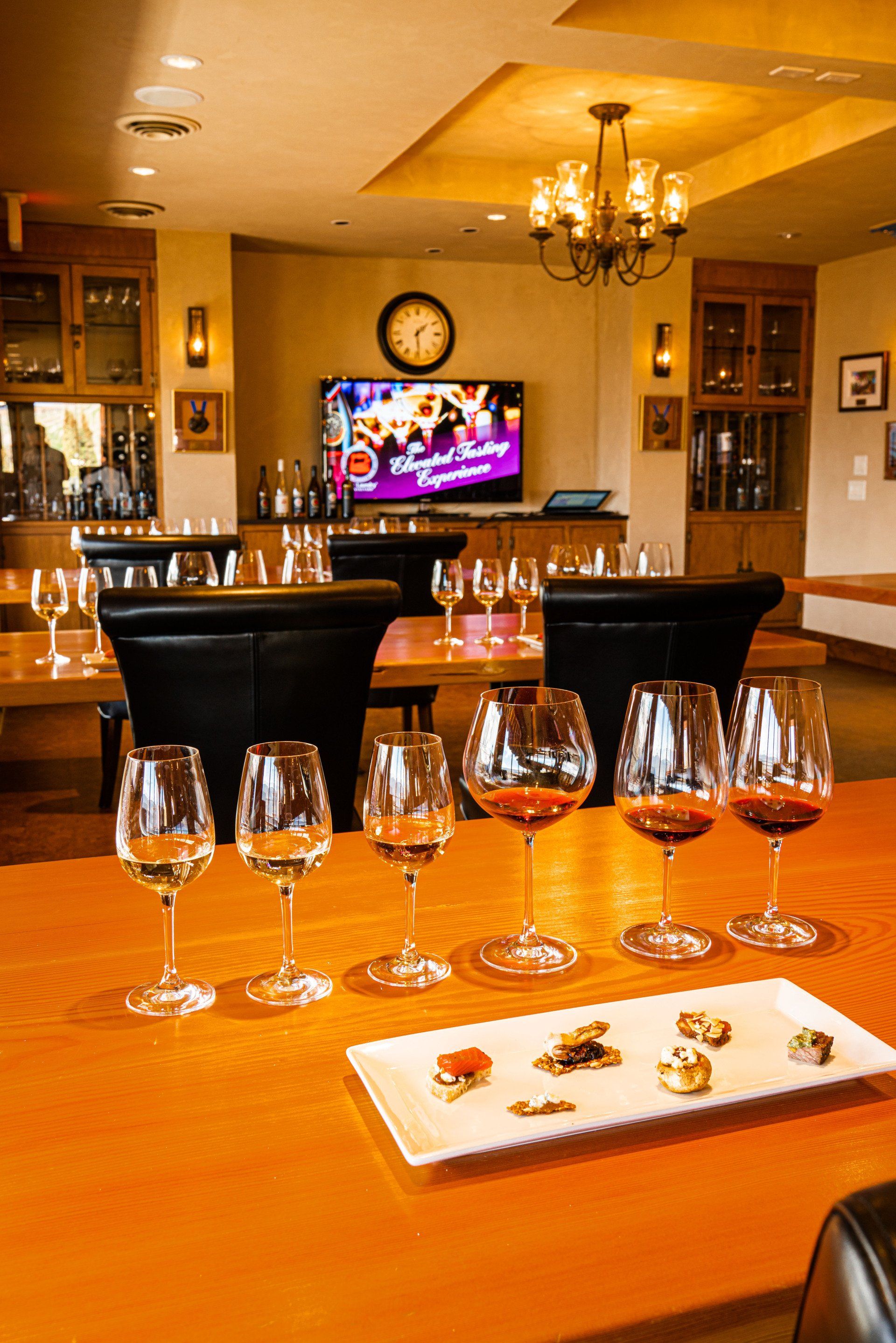 A row of wine glasses sitting on top of a wooden table.