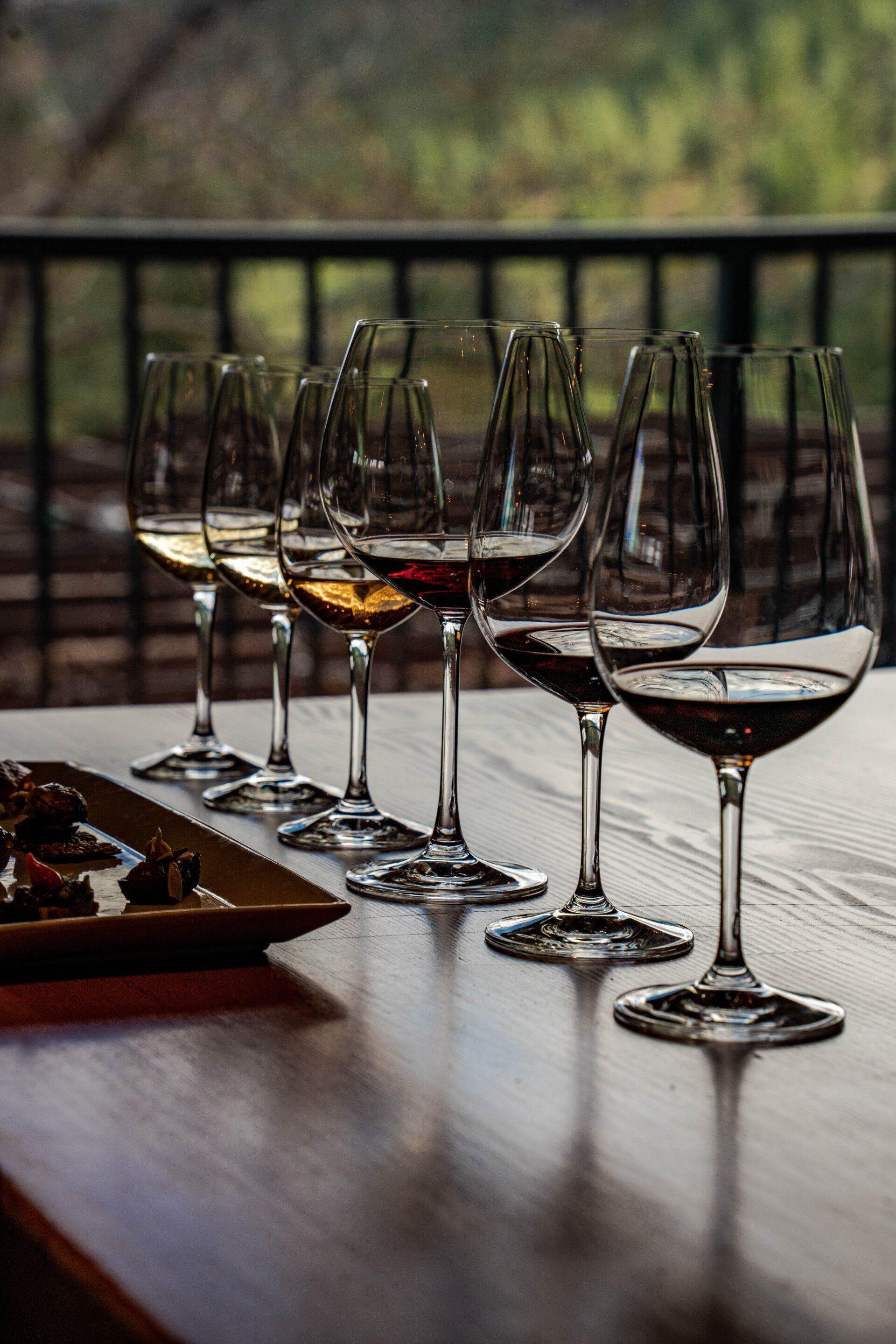 A row of wine glasses sitting on top of a wooden table.