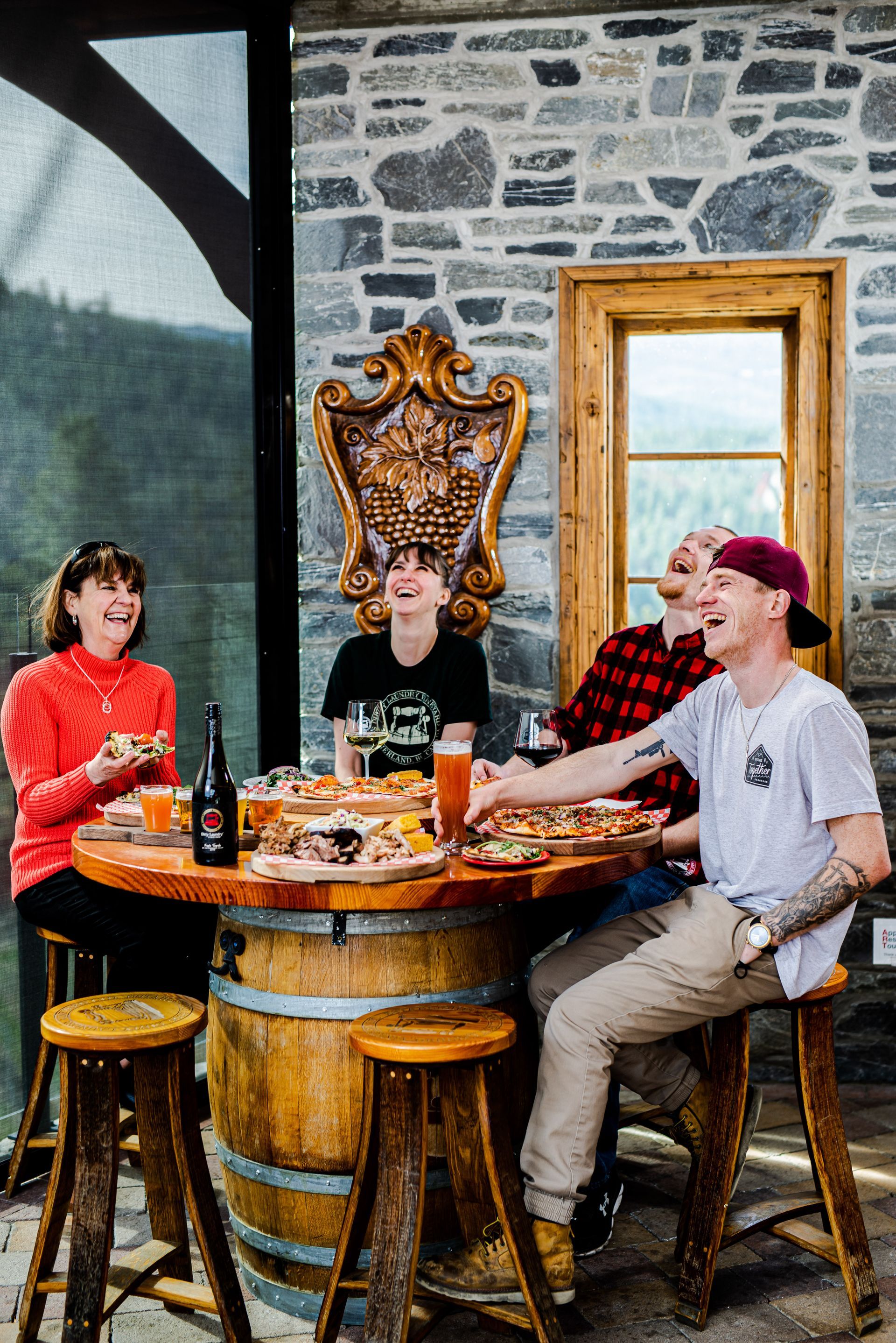 A group of people are sitting around a wooden table eating food.