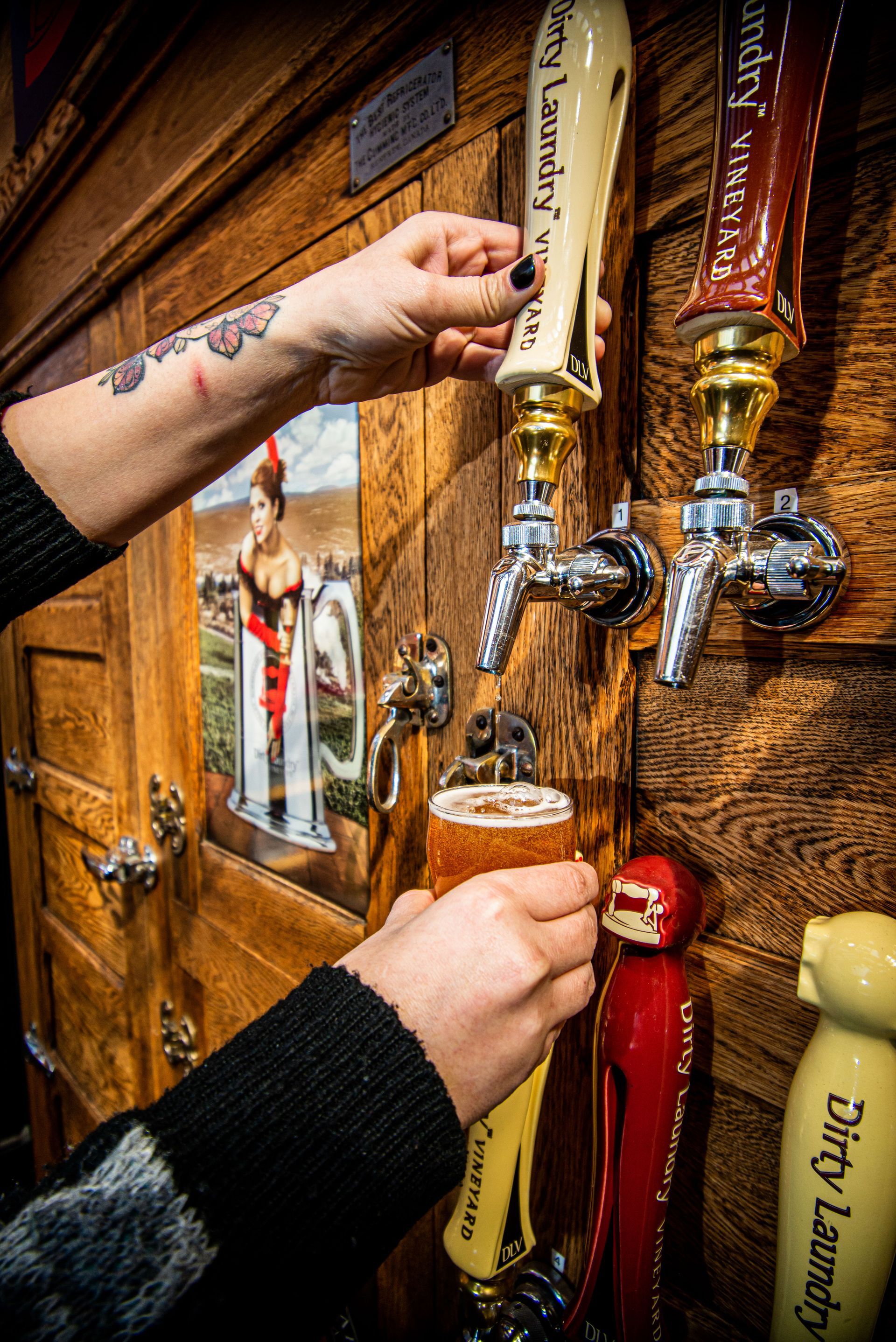 A person is pouring beer from a tap in a bar.
