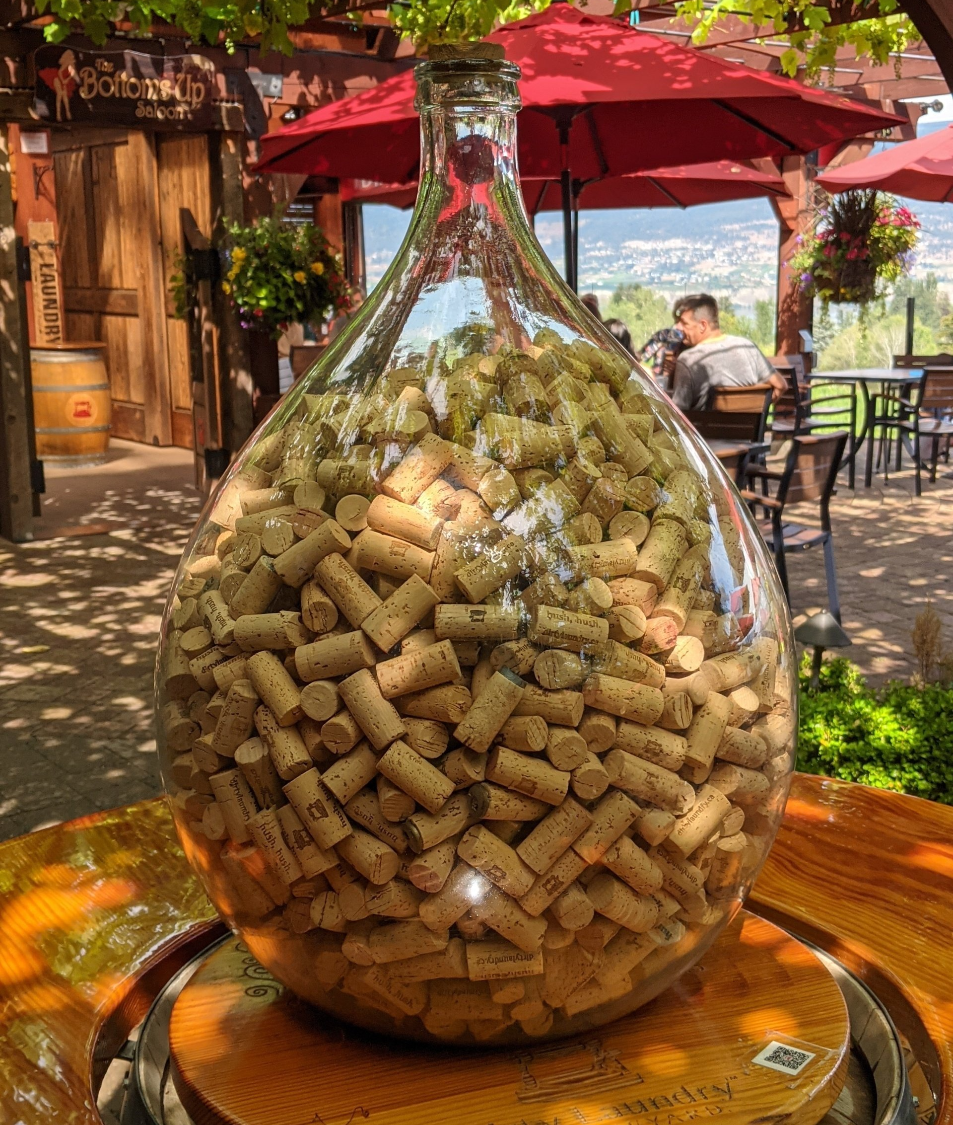 A glass bottle filled with wine corks is sitting on a table.