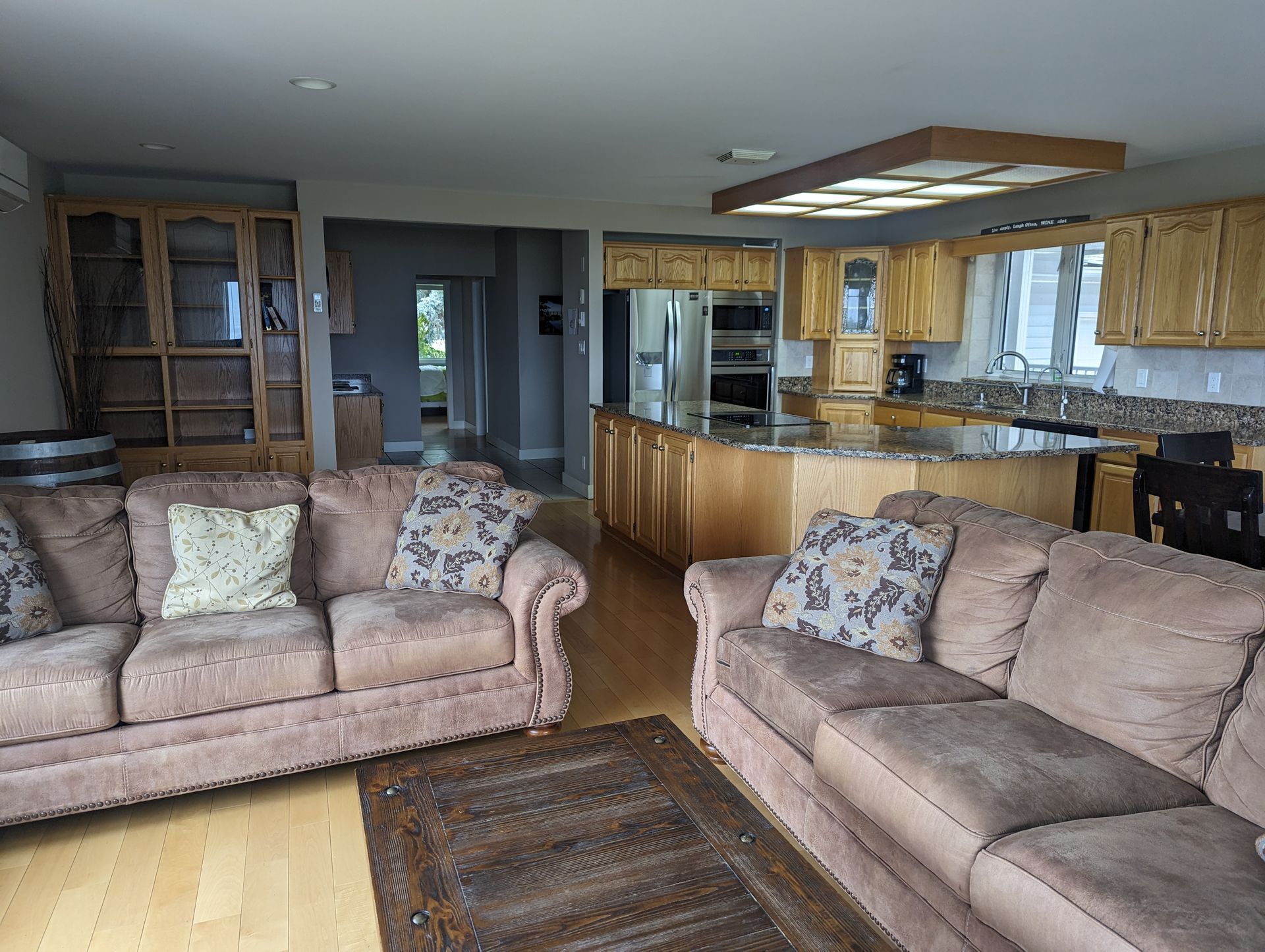 A living room with two couches and a kitchen