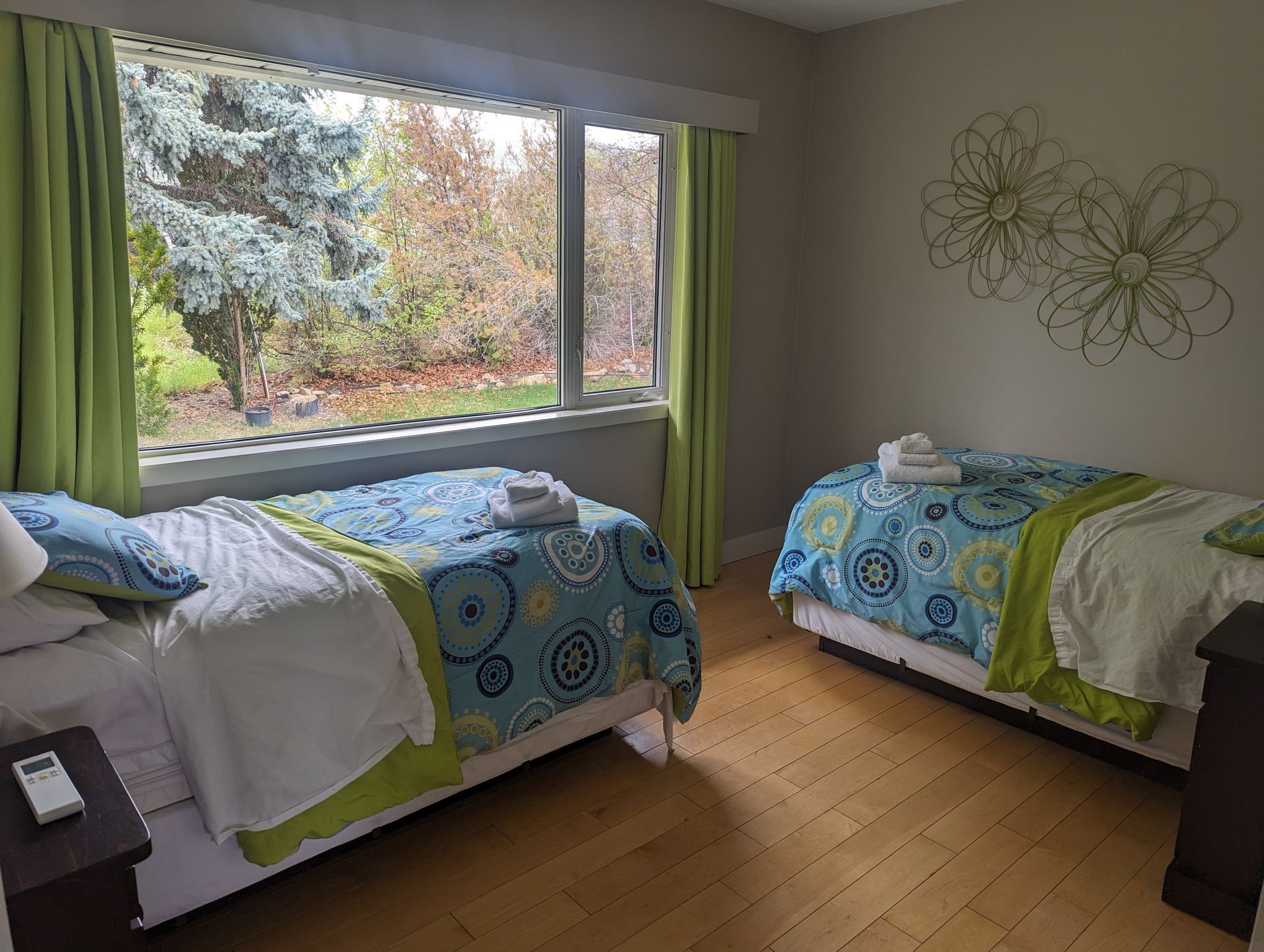 A bedroom with two beds and a large window.