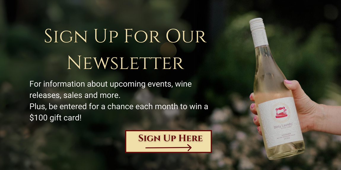 A person is holding a bottle of wine in front of a sign that says sign up for our newsletter