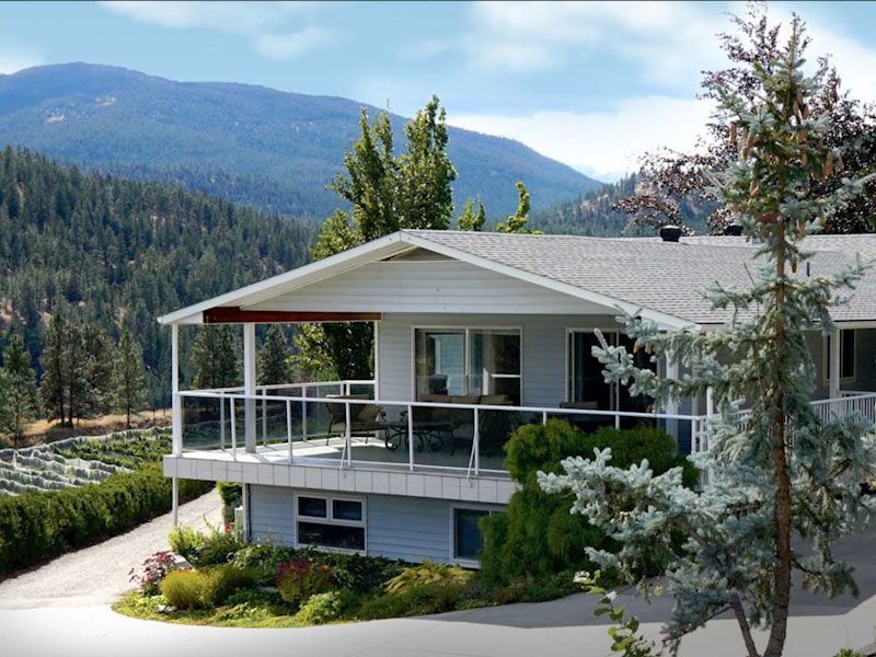 A house with a balcony and mountains in the background