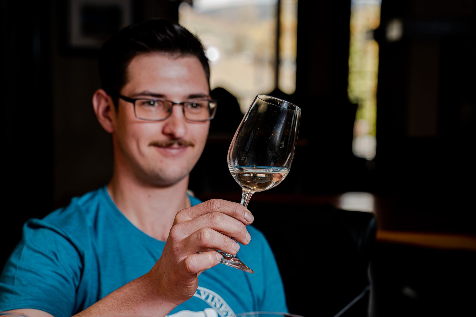 A man is holding a glass of wine in his hand.