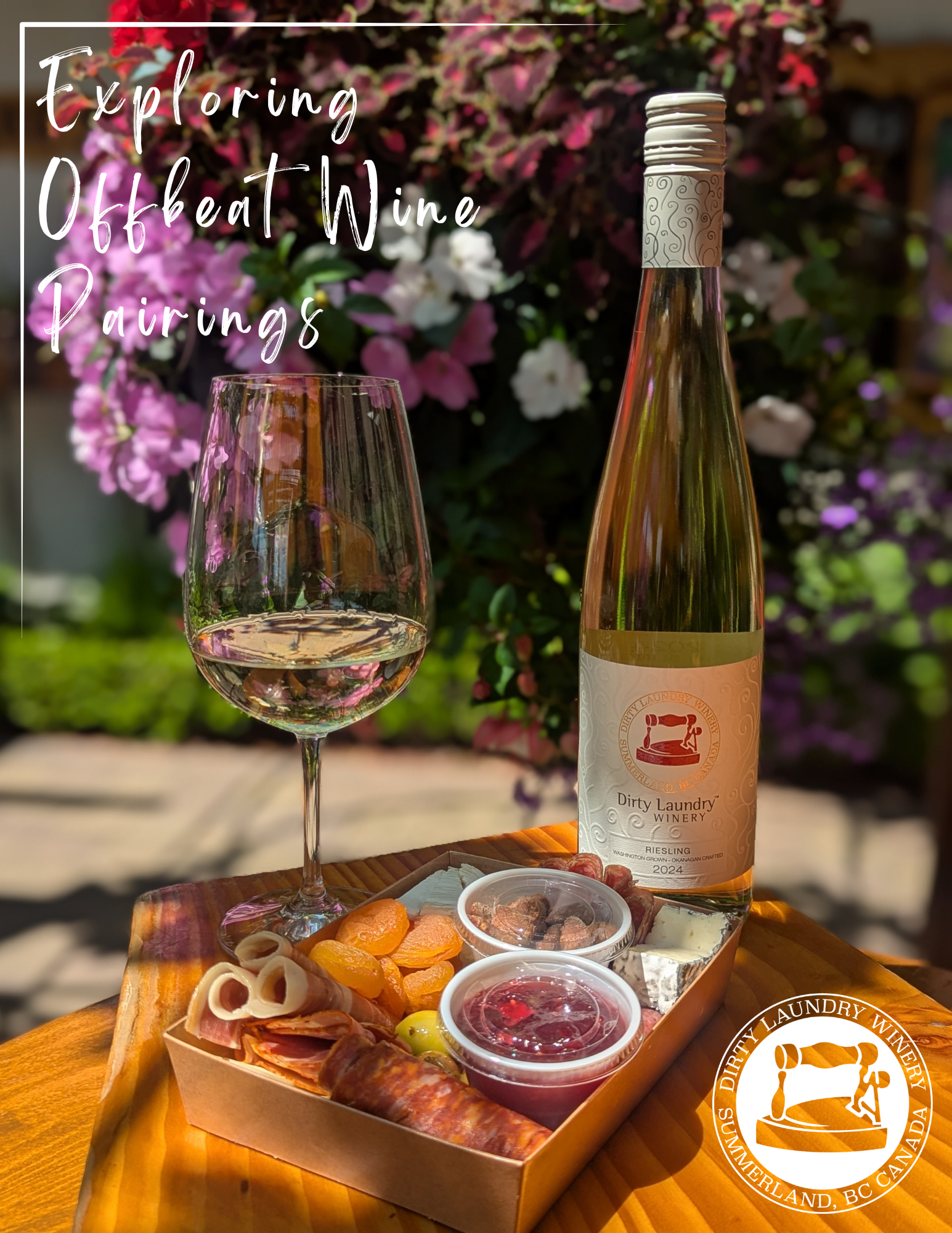 A bottle of wine and a glass of wine are on a wooden table with cheese and meats.