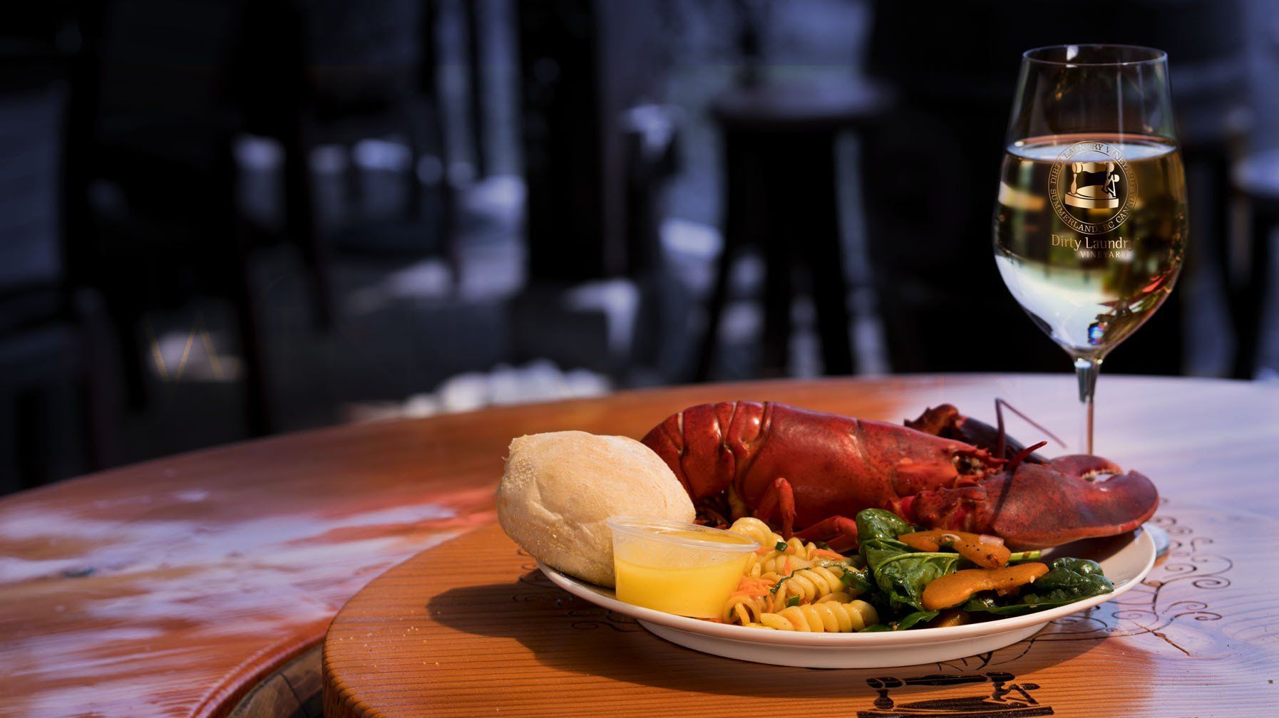 A plate of food and a glass of wine on a wooden table.