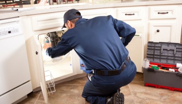 Plumber performing routine plumbing maintenance in a Castle Rock, Colorado home.