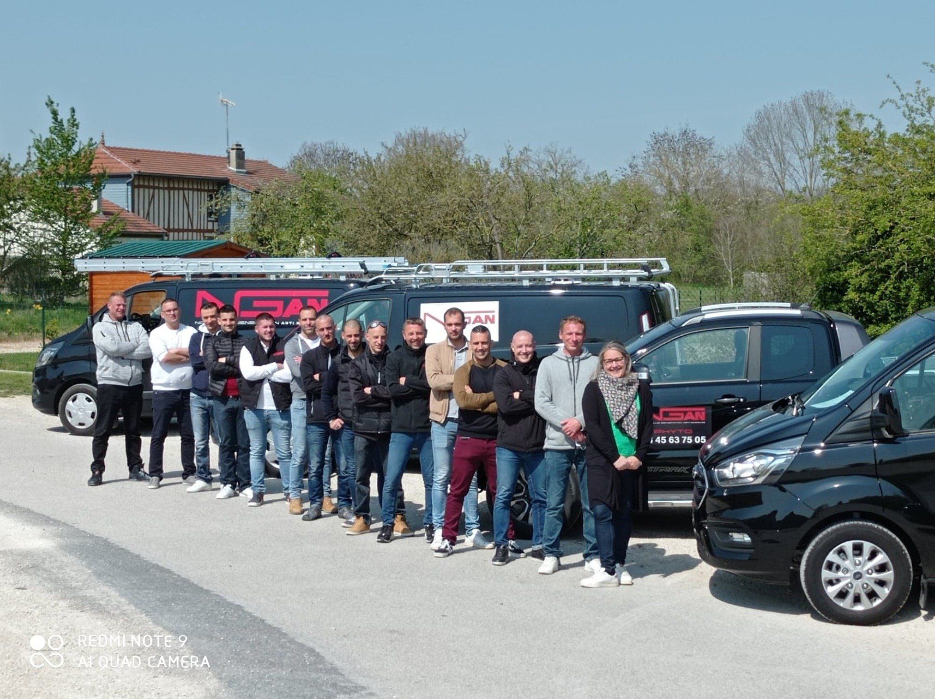 Un groupe de personnes debout devant une rangée de camionnettes.