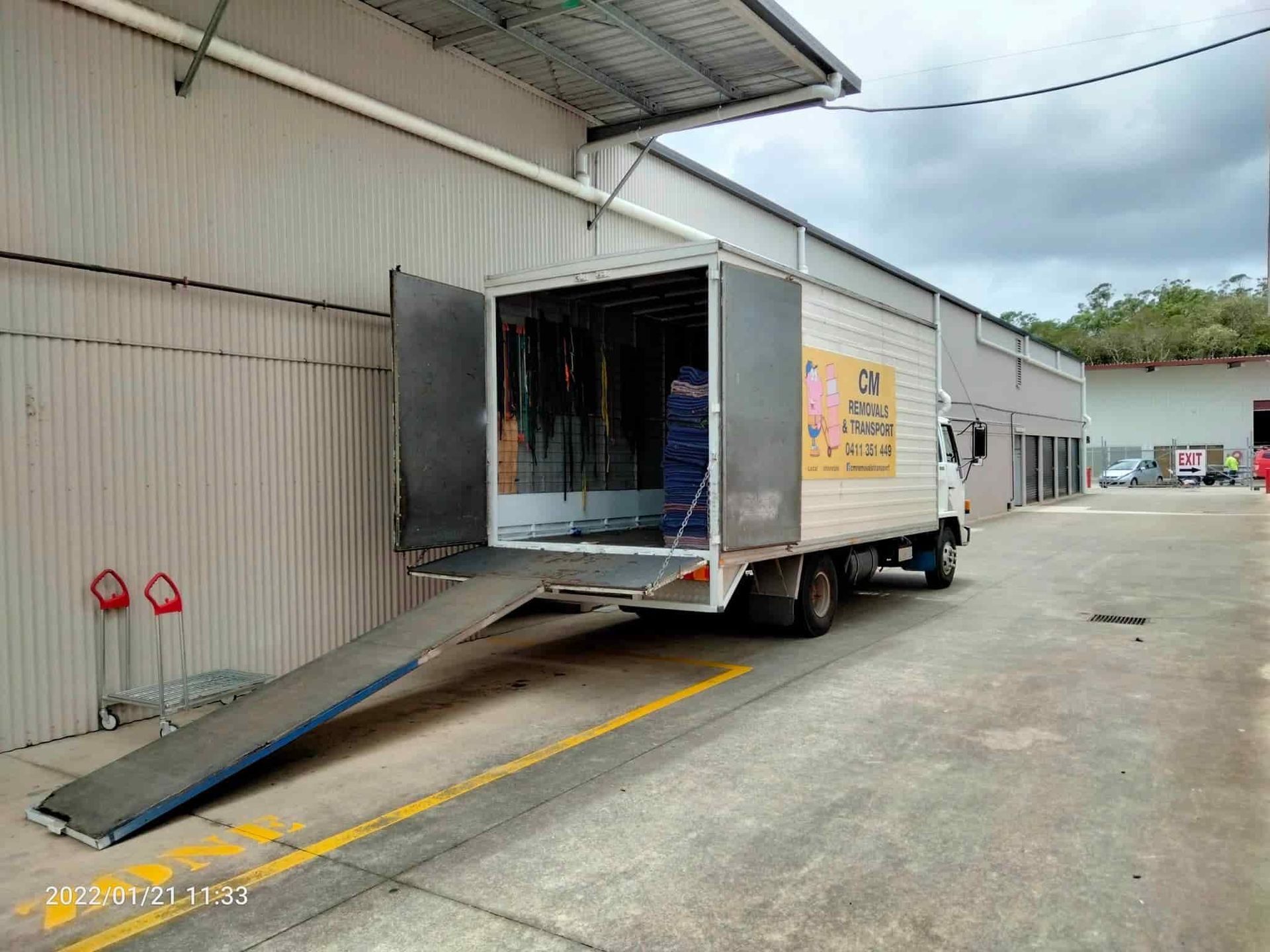 a Moving Truck is Parked in Front of a Building With Its Ramp Open — CM Removals & Transport In Gympie, QLD